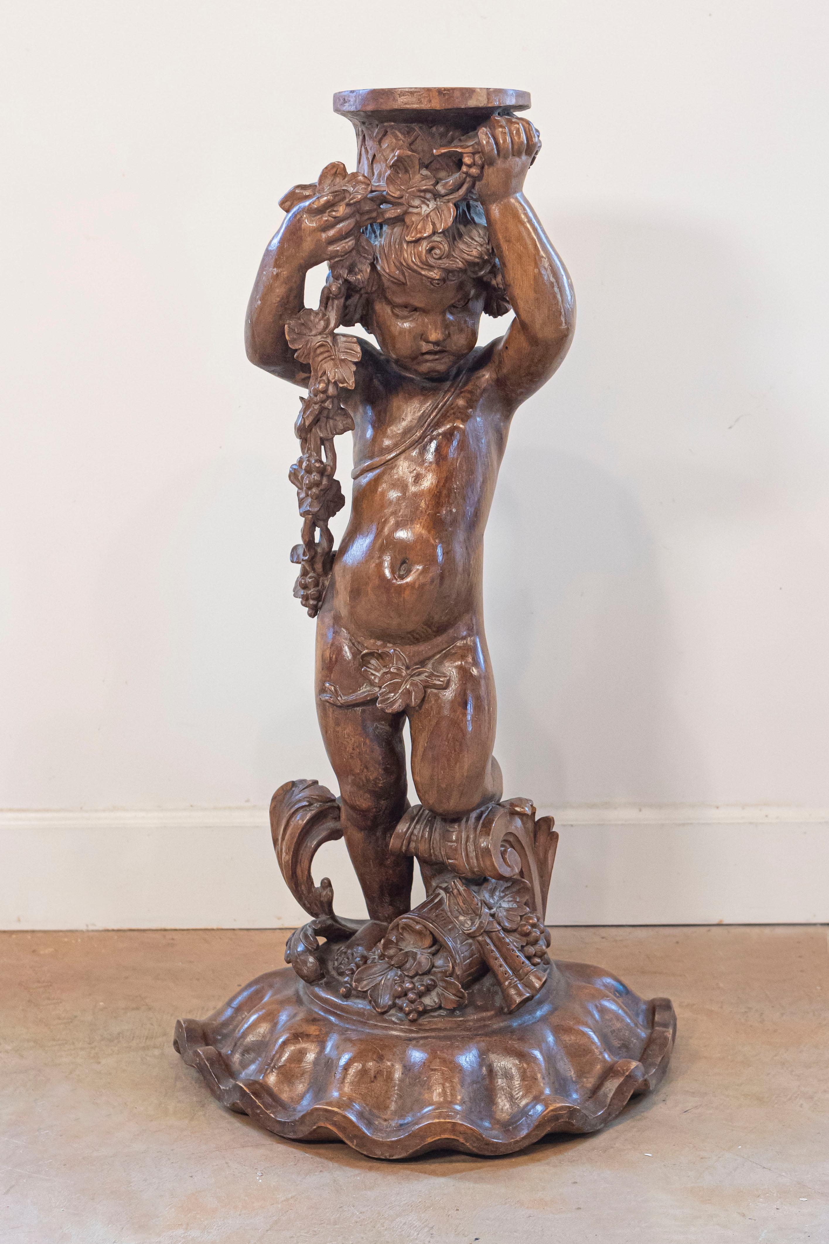 Sculpture en noyer sculpté d'époque Napoléon III, datant du milieu du XIXe siècle, représentant des raisins, des fleurs et une double flûte. Créée en France dans le troisième quart du XIXe siècle, cette sculpture en noyer sculpté représente un putto