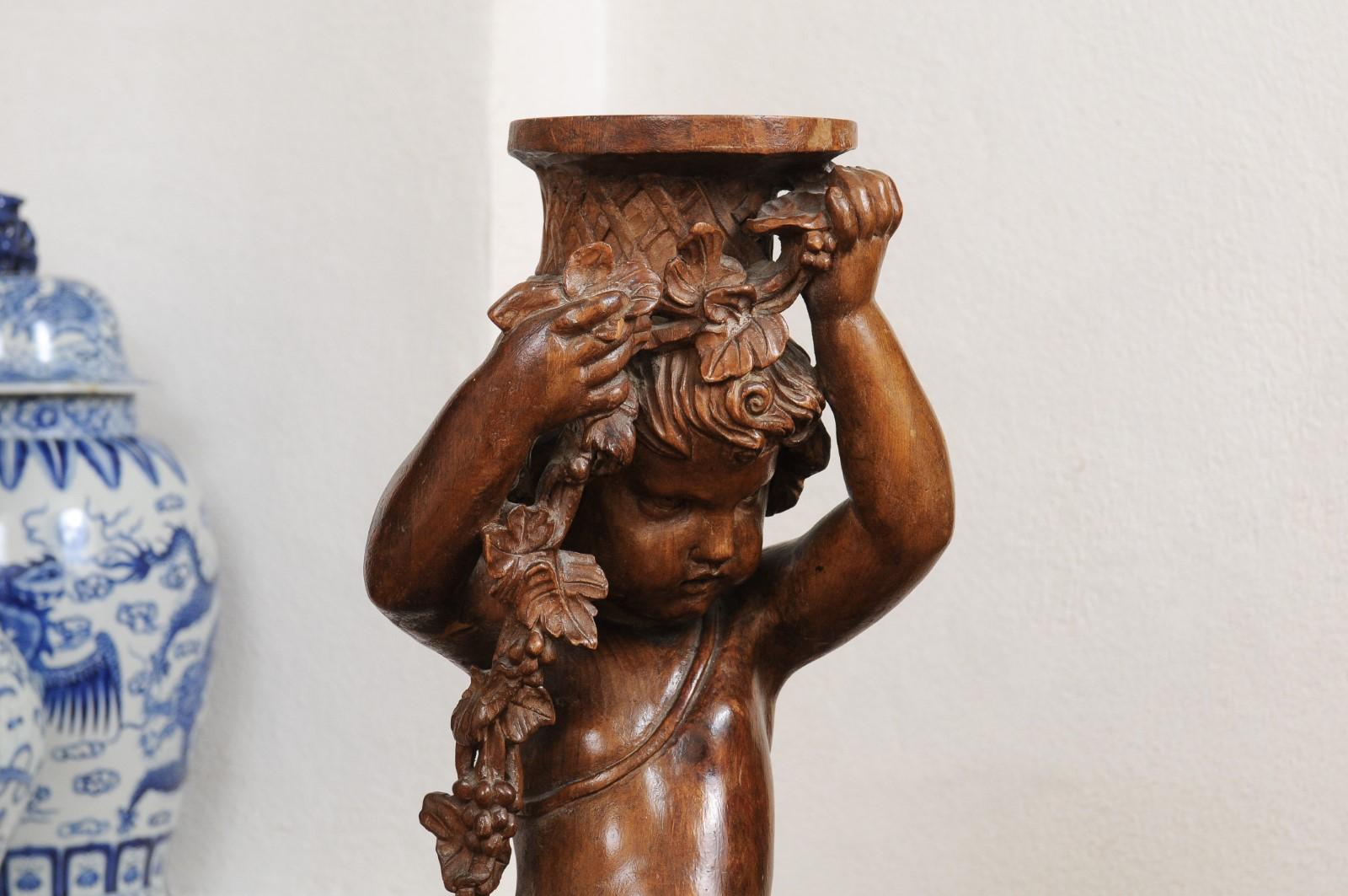 Français Sculpture en noyer sculpté des années 1860 représentant un putto portant un vase en vente