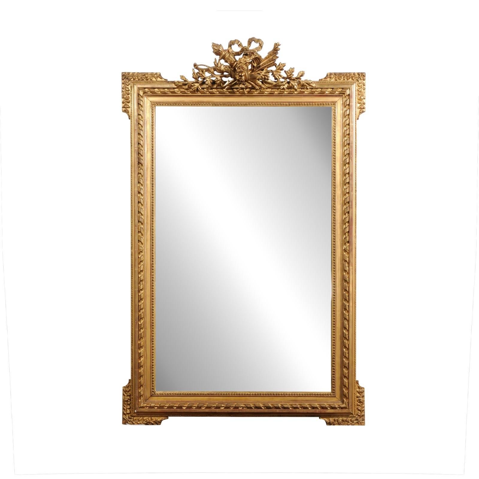 Miroir en bois doré d'époque Napoléon III, datant de la fin du XIXe siècle, avec une crête sculptée représentant un trophée de chasse, des rubans tordus et des petites perles. Créé en France au cours du troisième quart du XIXe siècle, ce miroir