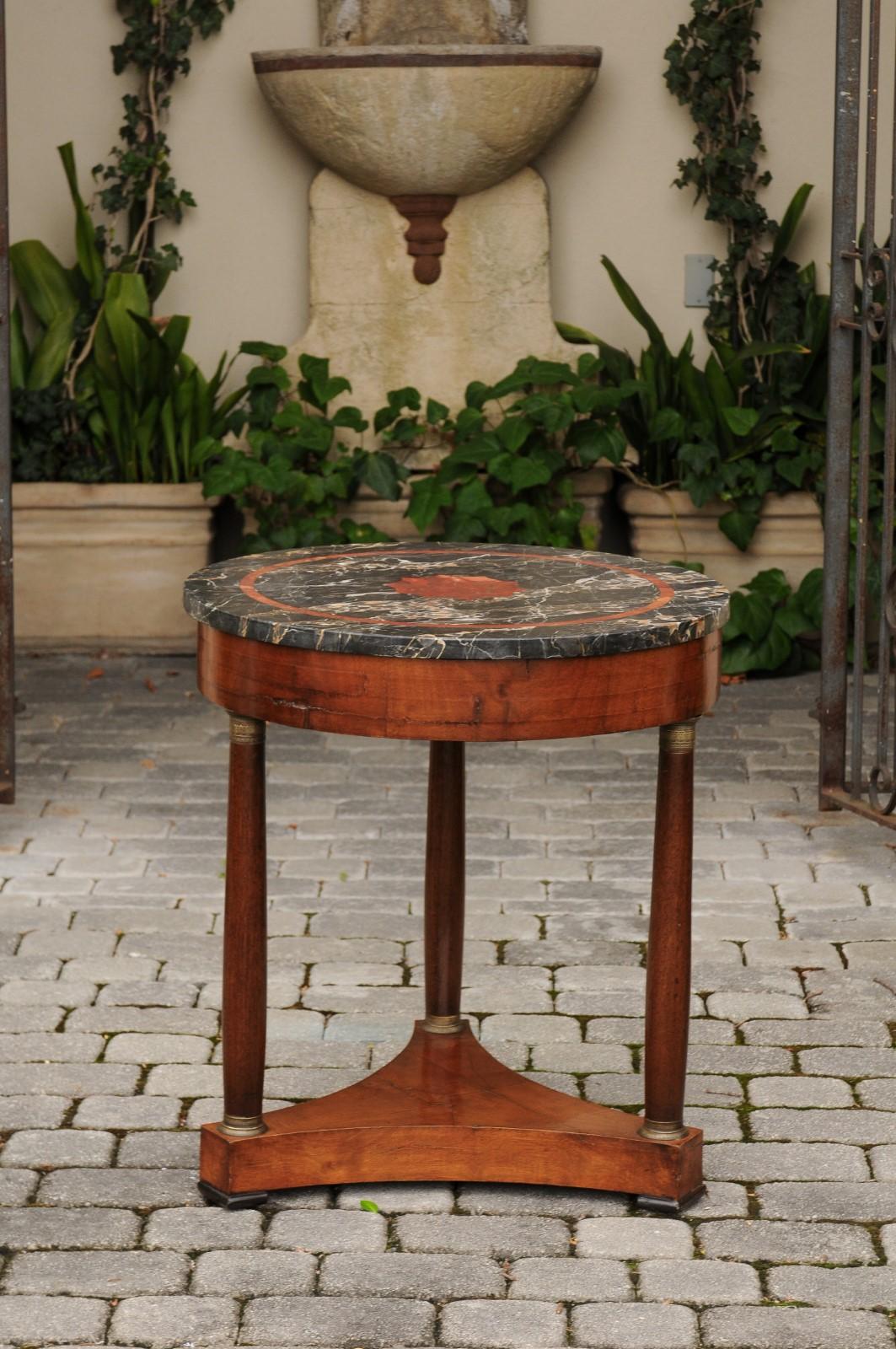 A French Napoleon III period walnut table from the third quarter of the 19th century, with variegated grey and red marble top, entasis columns and bronze capitals. Born in France at the end of emperor Napoleon III's reign, this exquisite table