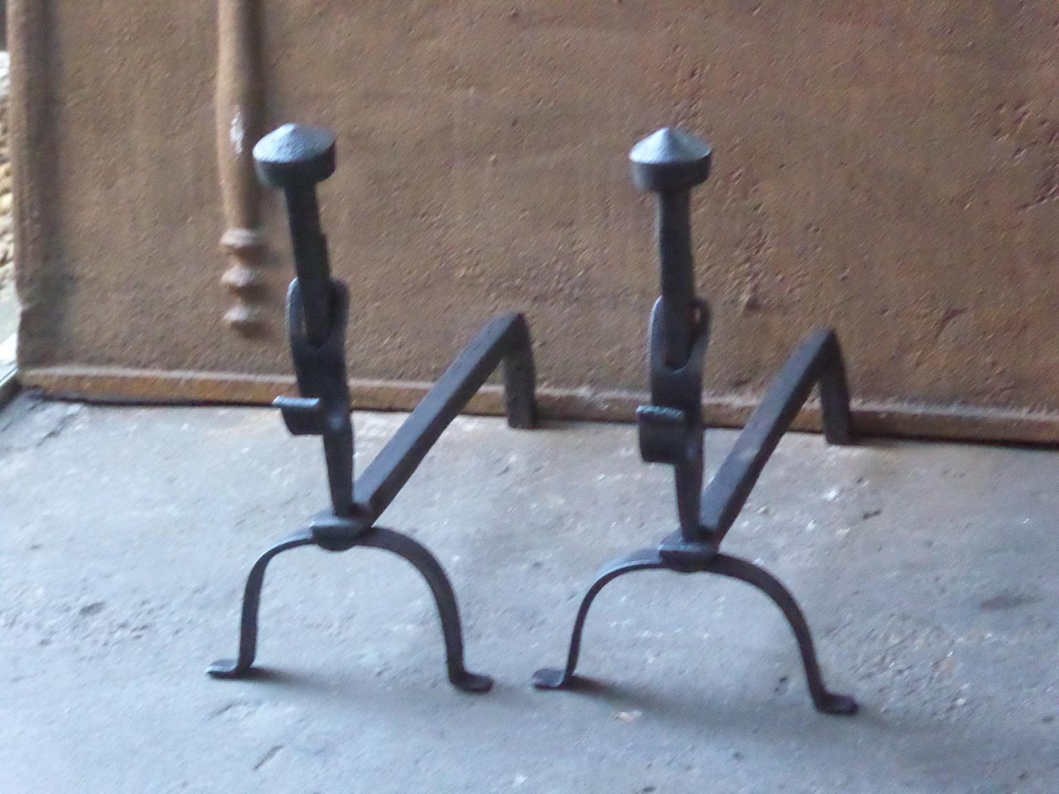 19th century French Napoleon III andirons made of wrought iron. The andirons have spit hooks to grill food. 

The andirons have a black / pewter patina. The andirons are in a good condition.