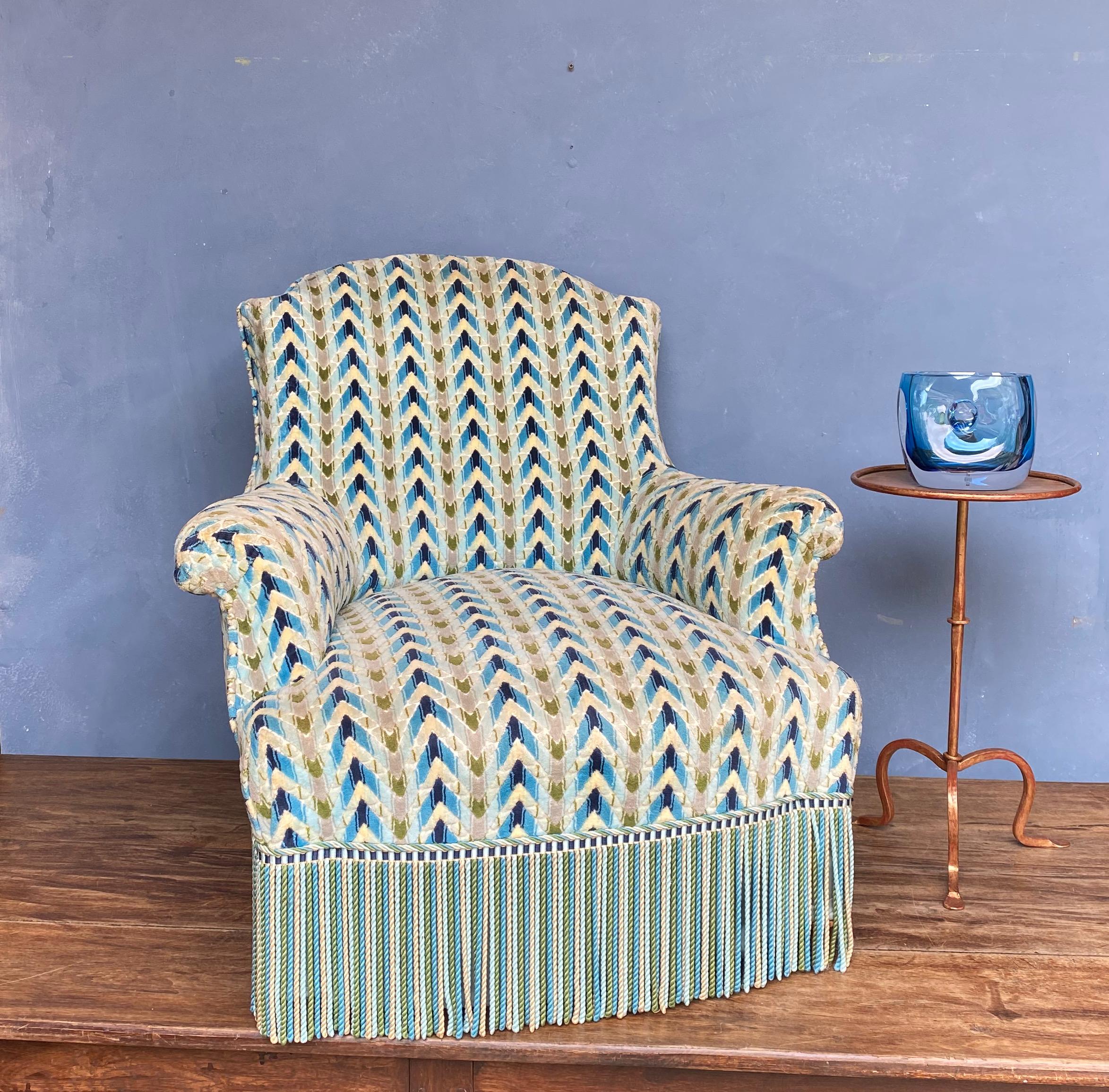 French 19th century Napoleon III arm chair upholstered in a blue, green and white geometric patterned velvet with contrasting bullion fringe. The chair is in good condition but the fabric does show signs of use and age. Sold as is. 

Dimensions: