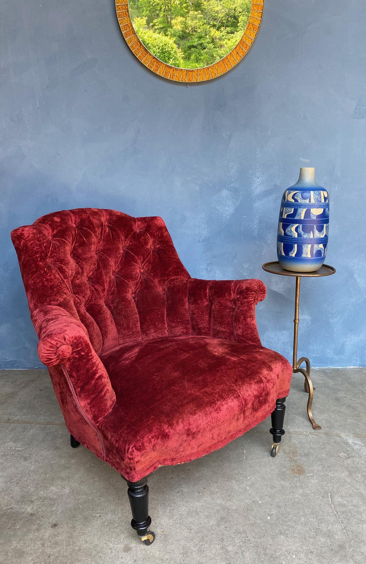 Extremely comfortable Napoleon III armchair with tufted back, upholstered in vintage rich red velvet. The legs have been recently refinished, and new casters have been installed on the front legs to accentuate the pitch. French, late 19th