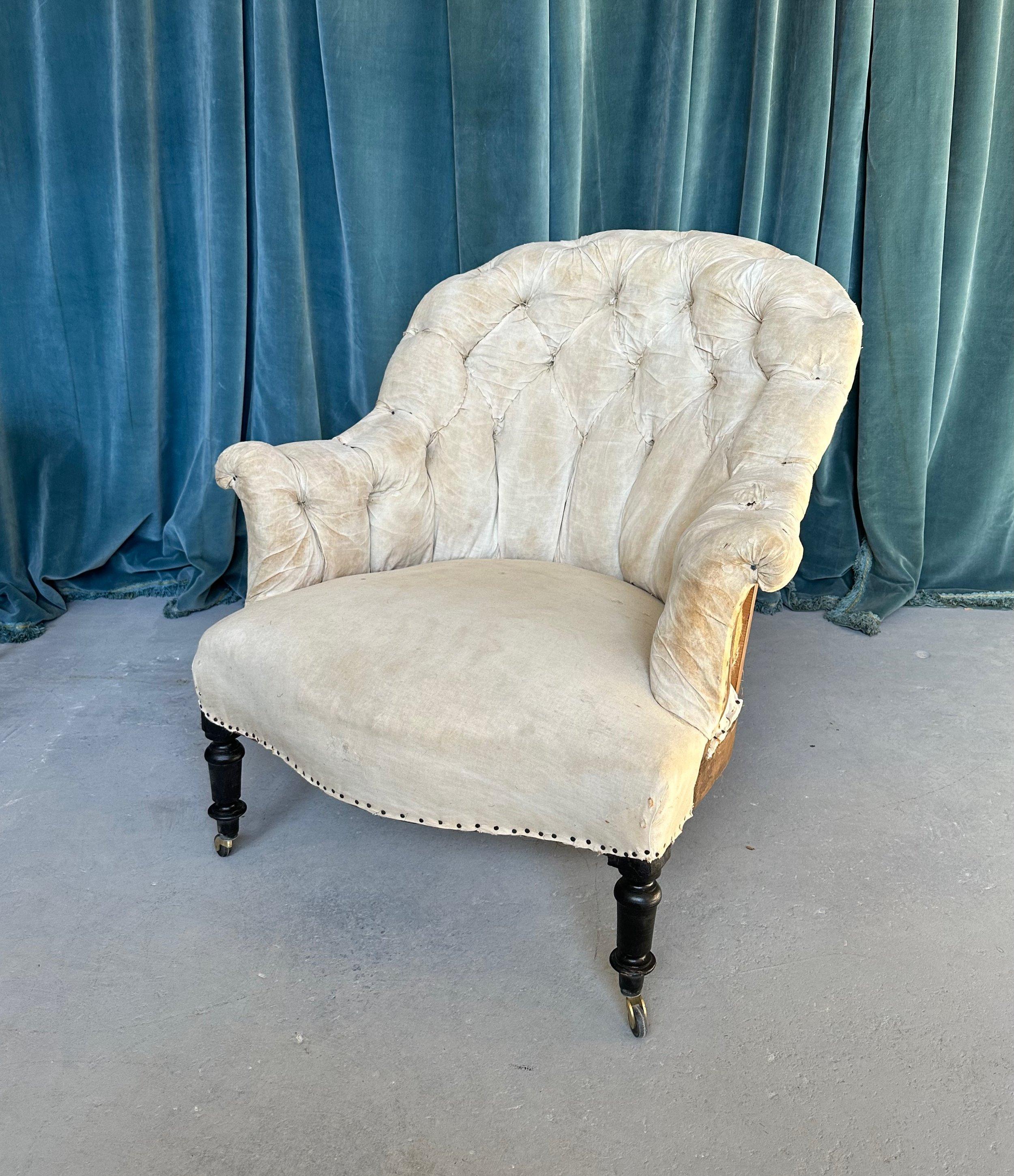 A handsome French 19th century armchair with diamond tufted back and scrolled arms. This elegant armchair from the Napoleon III period captures the intricate details and romantic beauty that is typical of this period in French design. The graceful