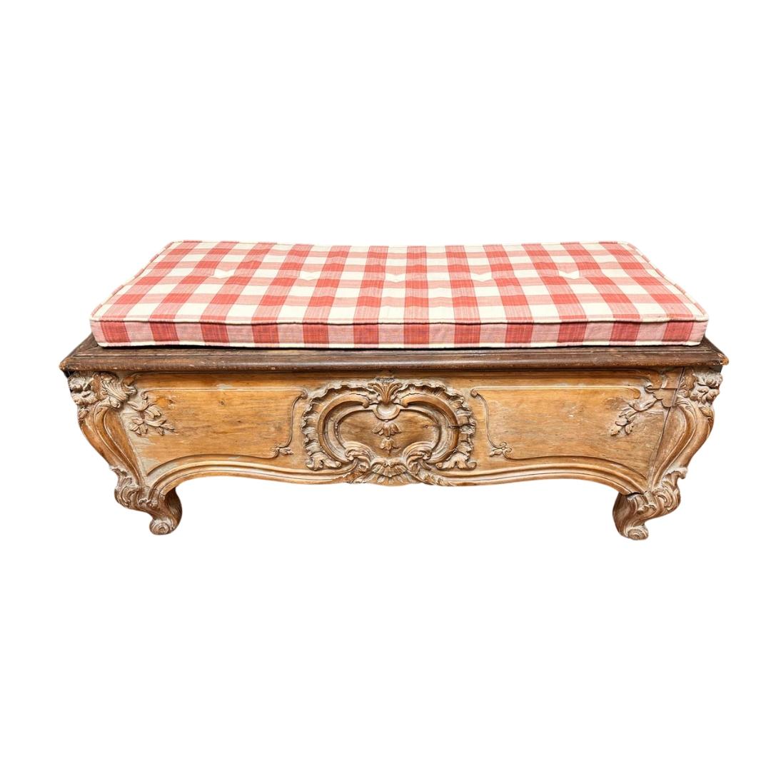 Magnifique et sophistiqué banc ou tabouret en bois français de style provençal. La façade et les côtés présentent d'élégants ornements sculptés de formes plaquées et végétales, qui courent sur tout le profil. Pieds cabriole courts. La beauté du bois