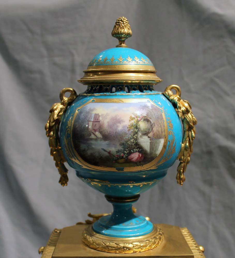 A very fine & attractive French porcelain & gilt bronze mantle clock. A superb dial & very finely painted urn surmounting the clock. To each side of the dial further painted panels. 8 day bell striking movement with steel suspended pendulum.