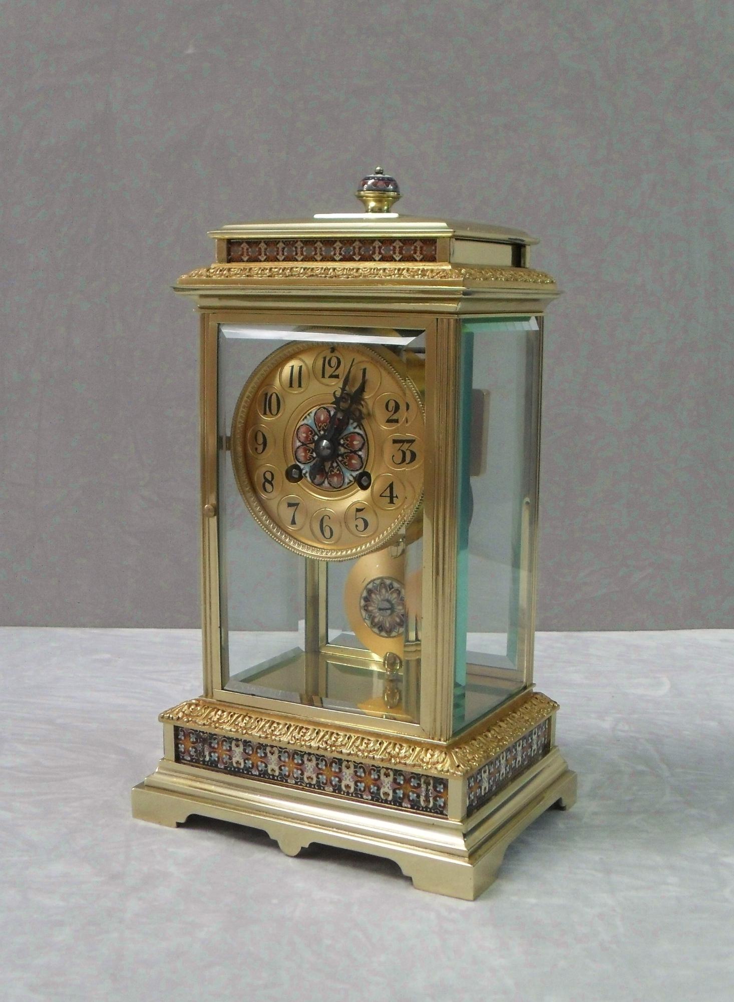 A very good quality French Napoleon III brass four glass mantel clock with reeded corners, acanthus leaf mouldings and decorative champleve coloured enamel ornamentation to the case, pendulum and dial. The clock has a brass dial with a French eight