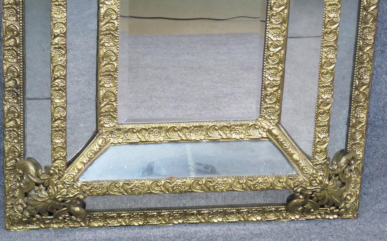 This is a fantastic antique French mirror. It is called a cushion mirror because it has a dimensional 3-D quality to it. This mirror has a beveled central mirror inset with the mirror frame. 

Measures: 47 tall x 29.25 wide x 3.