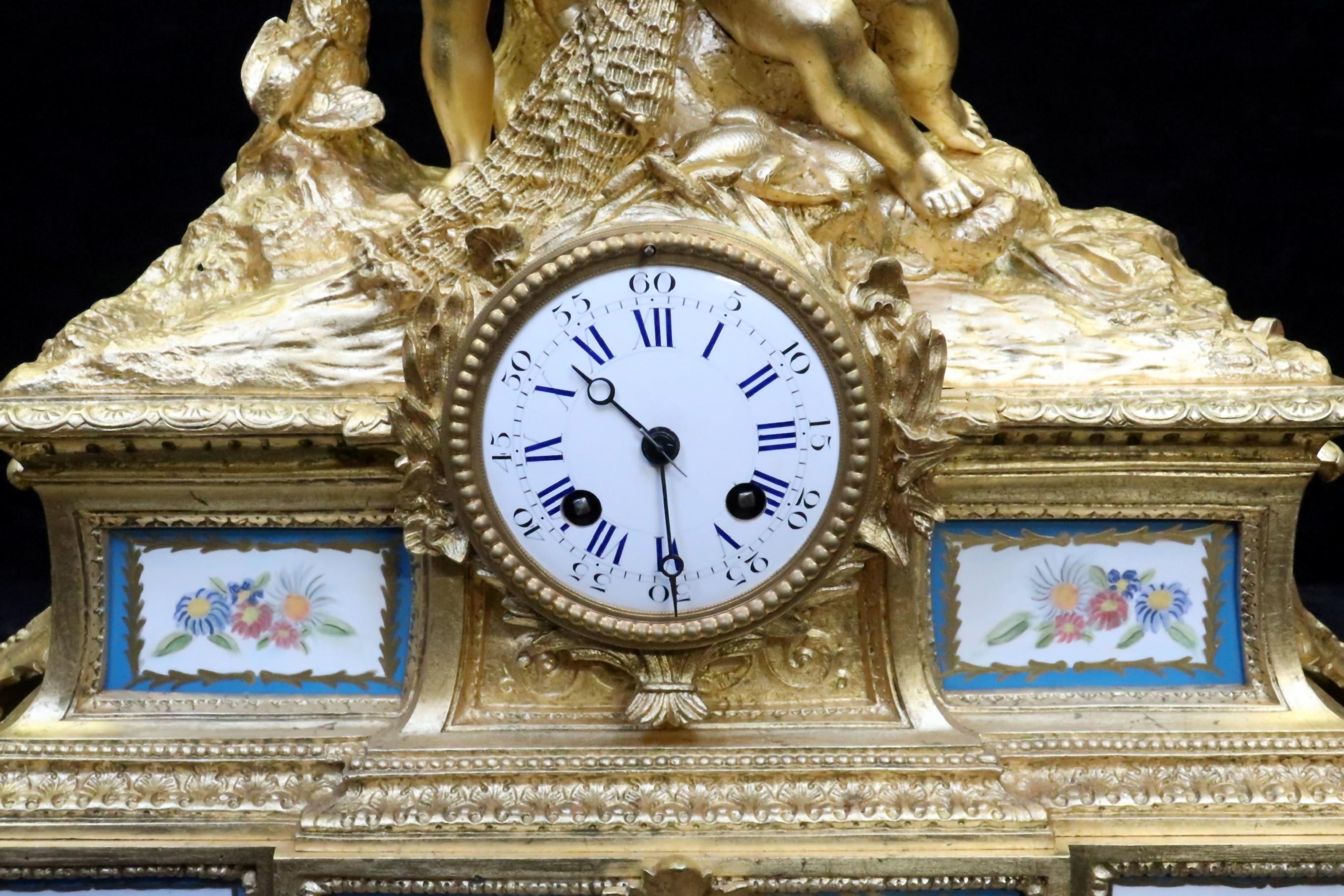 A very impressive French bronze gilt mantel clock with scrolling leaf, acanthus leaf and decorative moulding design throughout with inset serve style porcelain panels painted with flowers within a gilt and blue border. The clock is surmounted with