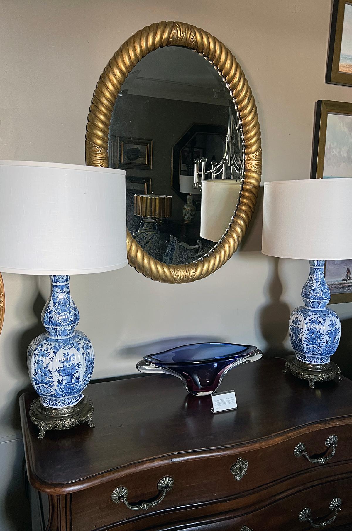 The boldly-carved rope-twist oval frame embellished with acanthus leaves all surrounding a later beveled mirror plate.