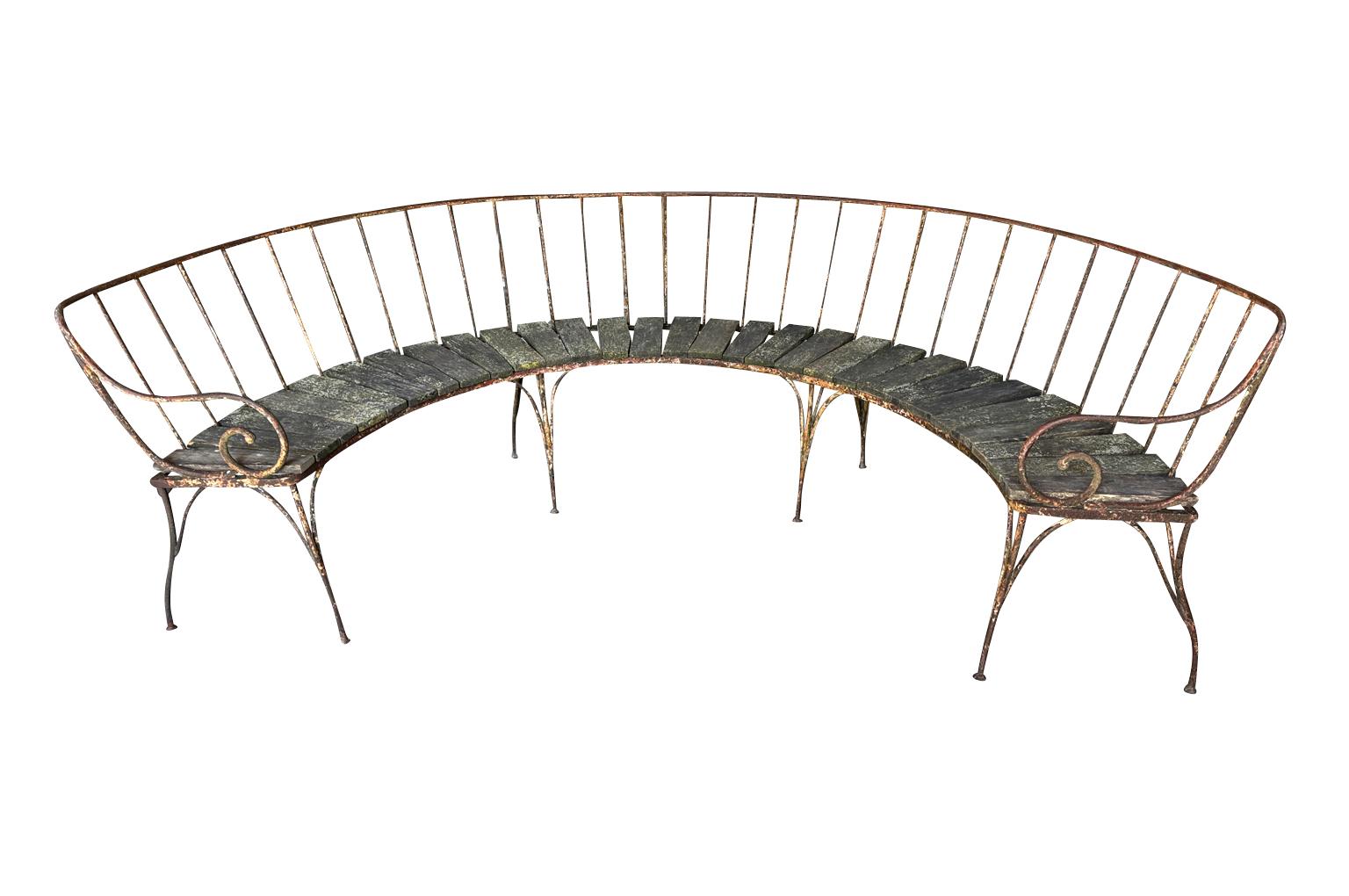 Banc de jardin en forme de demi-lune Napoléon III du XIXe siècle, de grande envergure, provenant de France.  Merveilleusement construit en fer et en bois.  Fabuleuse patine.  Parfait pour tout jardin ou solarium.  La hauteur du siège est de 19