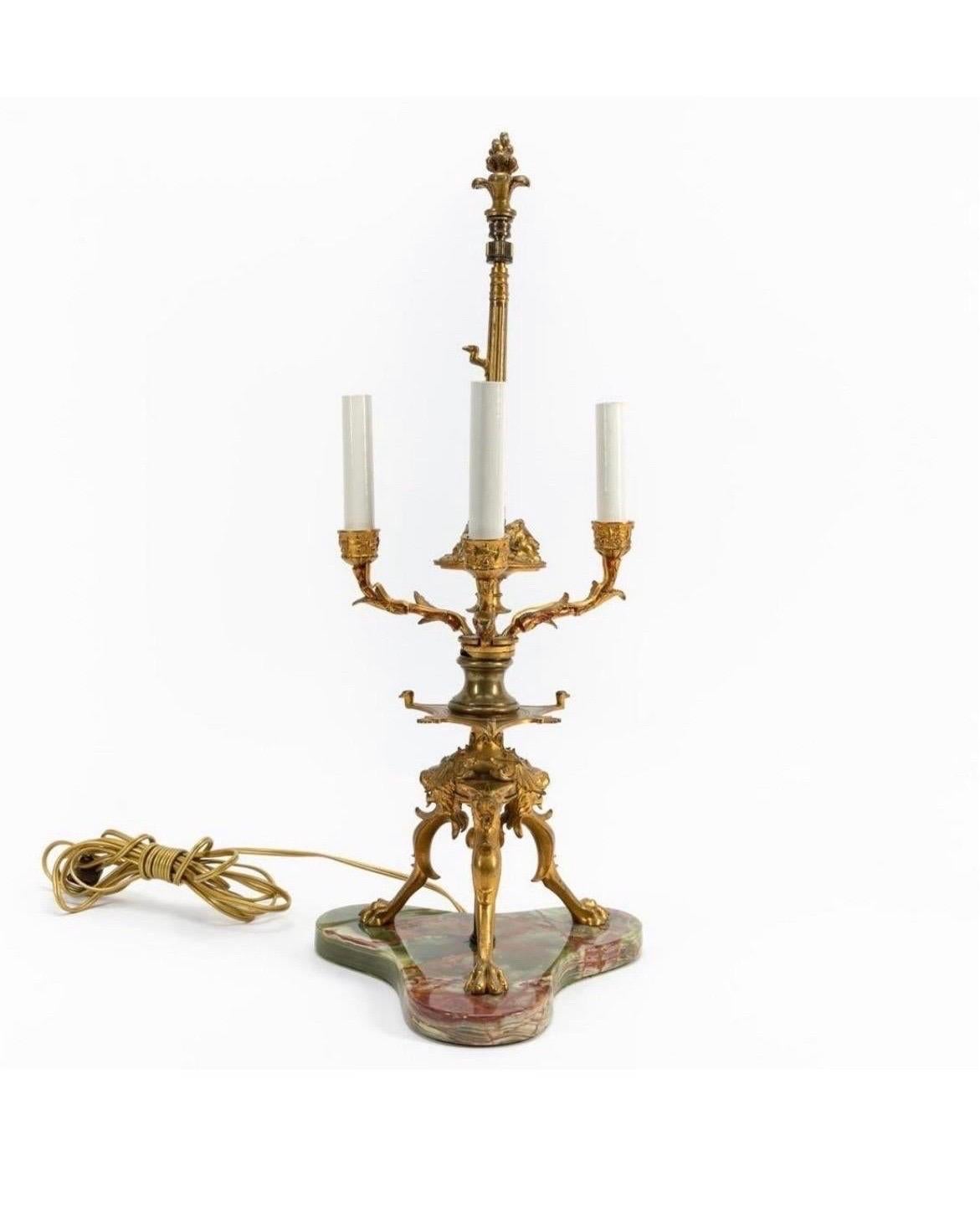 French, 19th century, cast gilt bronze three-light bouillotte lamp, now electrified, having a black paper shade, and rising on paw feet, mounted on a green onyx base. Unmarked. Measures: Approx. overall, height. 24
