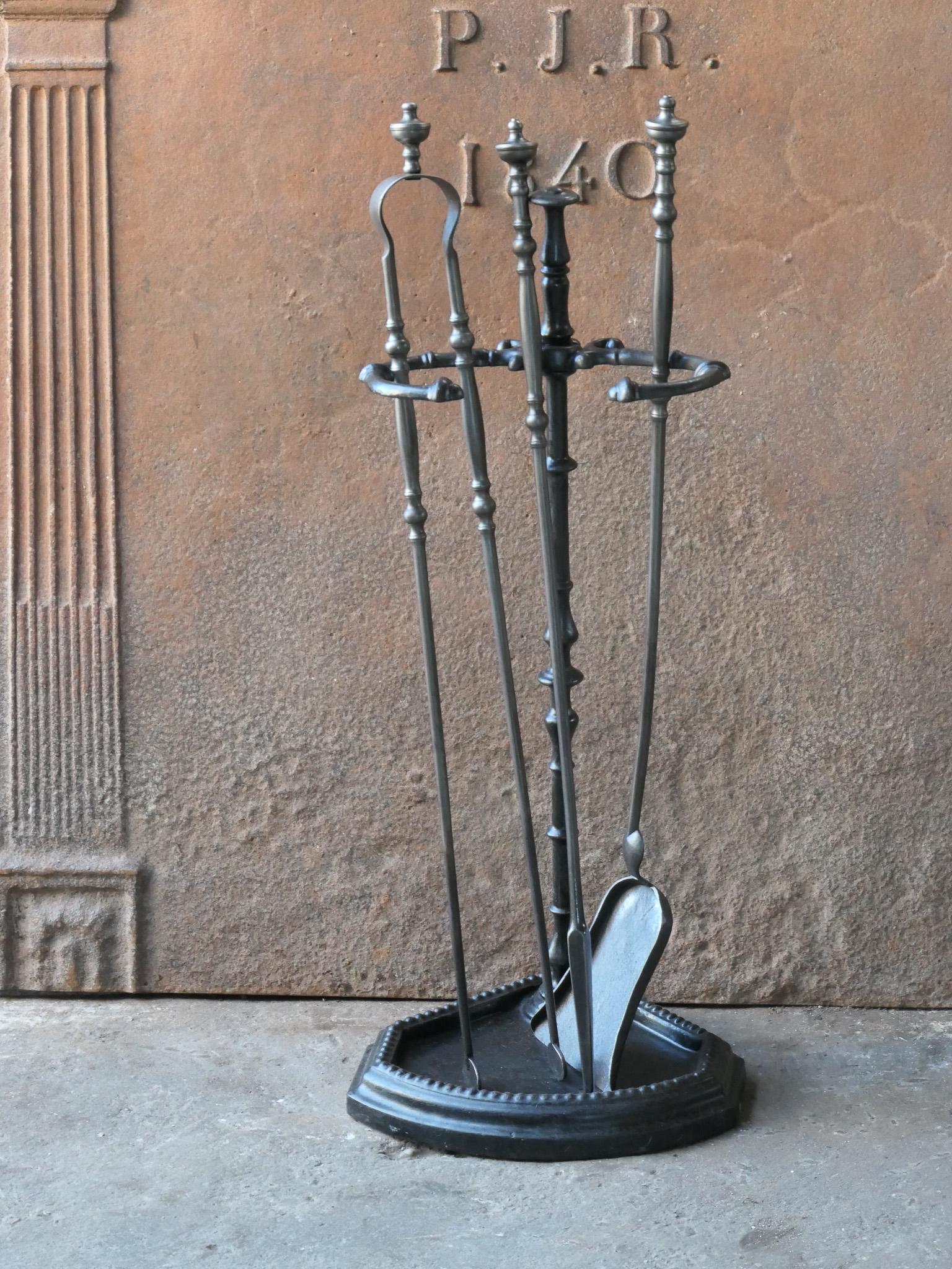 19th century French fireplace tool set. The tool set consists of tongs, shovel, poker and a stand. The tools are made of wrought iron and the stand of cast iron. The set is in a good condition and fit for use in the fireplace.