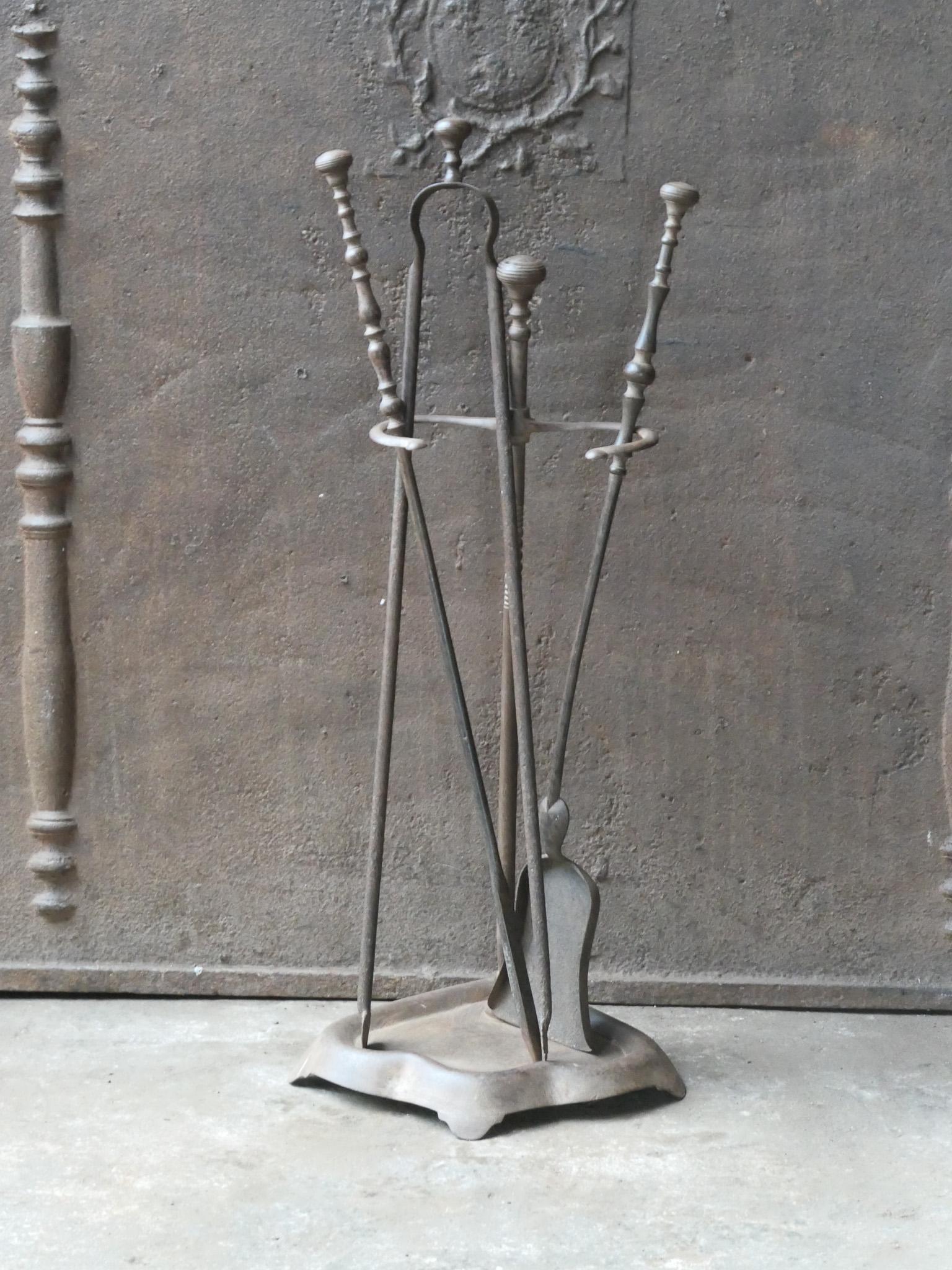 19th century French fireplace tool set. The tool set consists of tongs, shovel, poker and a stand. The tools are made of wrought iron and the stand of wrought and cast iron. The set is in a good condition and fit for use in the fireplace.