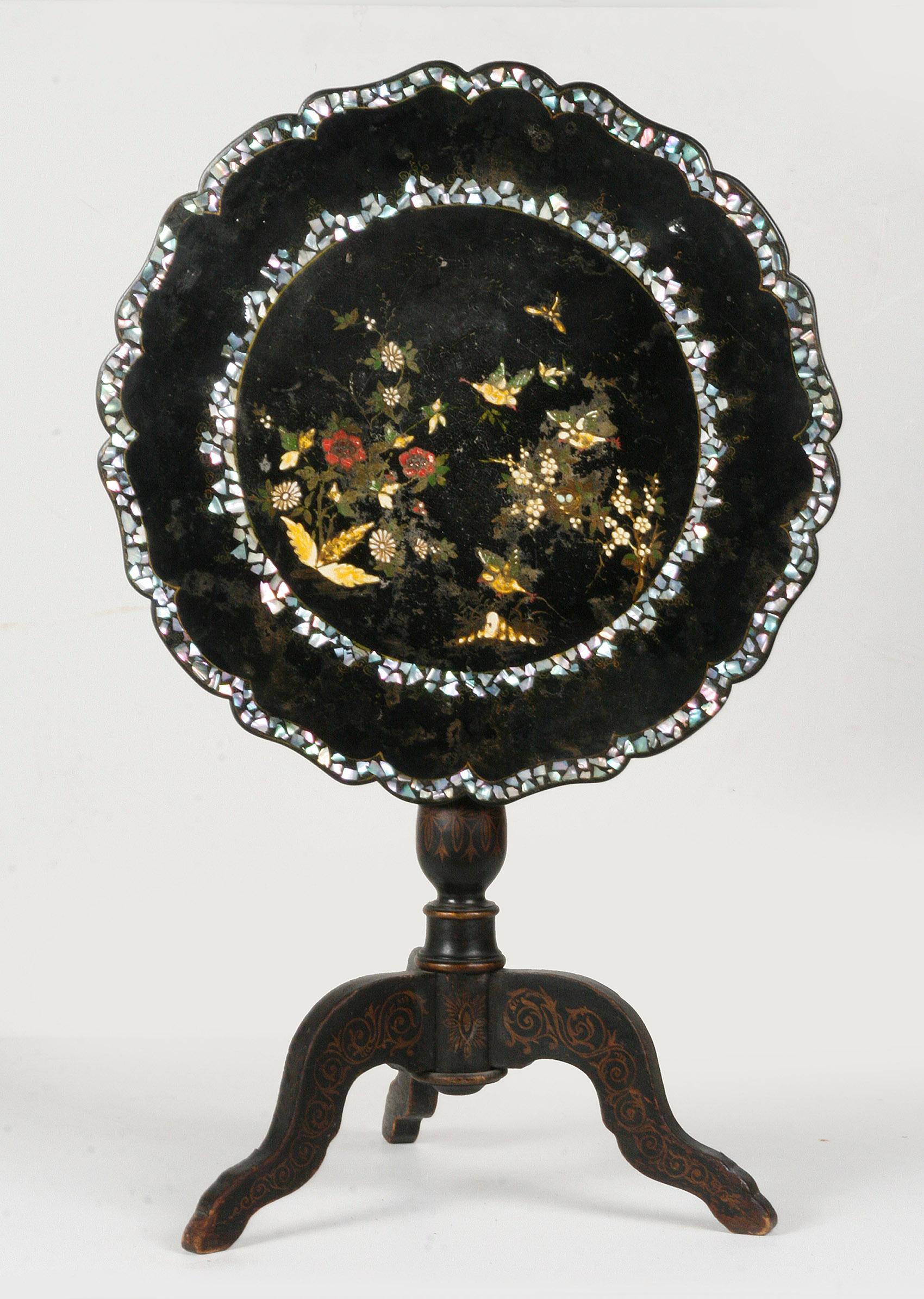 An antique French tilt-top table from the Napoleon III period.
The table is made of wood (a softwood type), with lacquer work, paintwork and inlays made of mother of pearl. The chassis is a tripod.
The tabletop tilts. This mechanism works