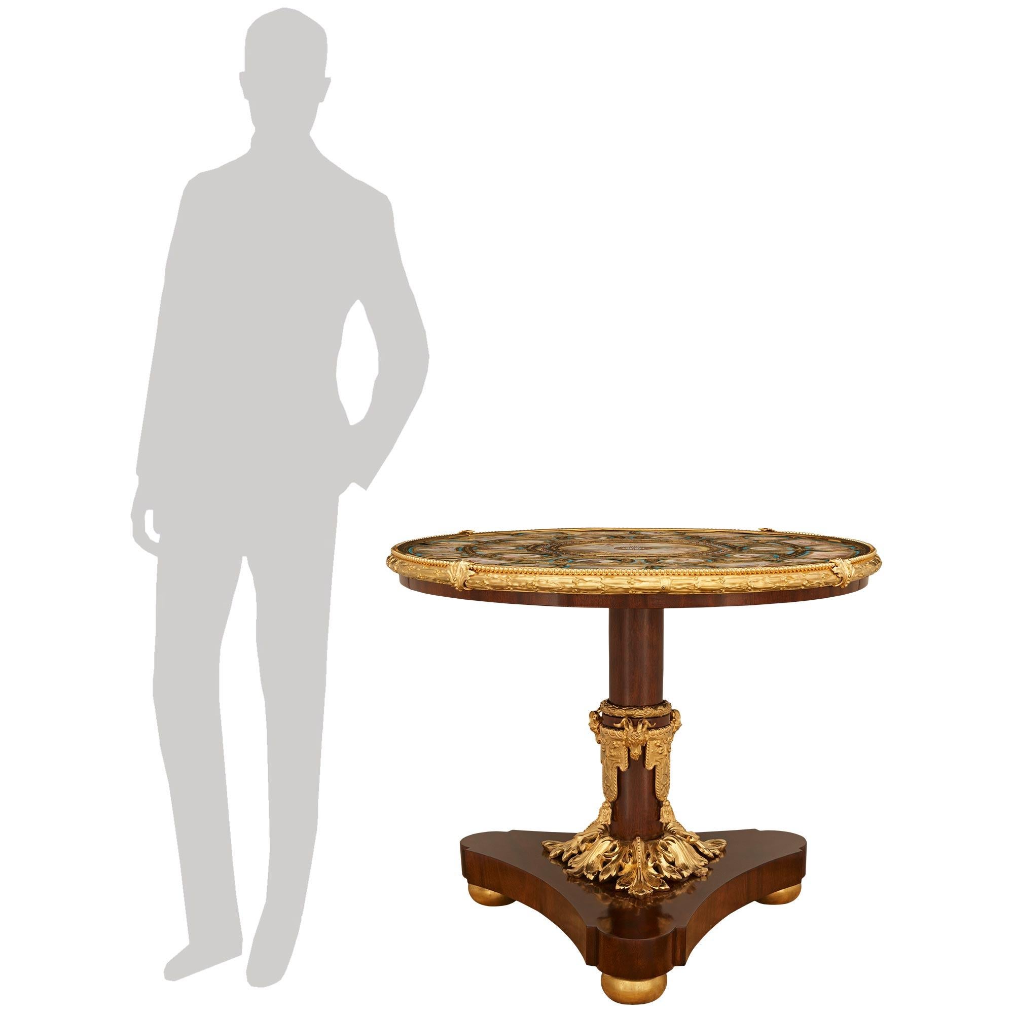 An exceptional and extremely high quality French 19th century Napoleon III Period Mahogany, Giltwood, Ormolu, and Sévres Porcelain center table. This sensational circular table is raised on a triangular Mahogany base with concave sides above three