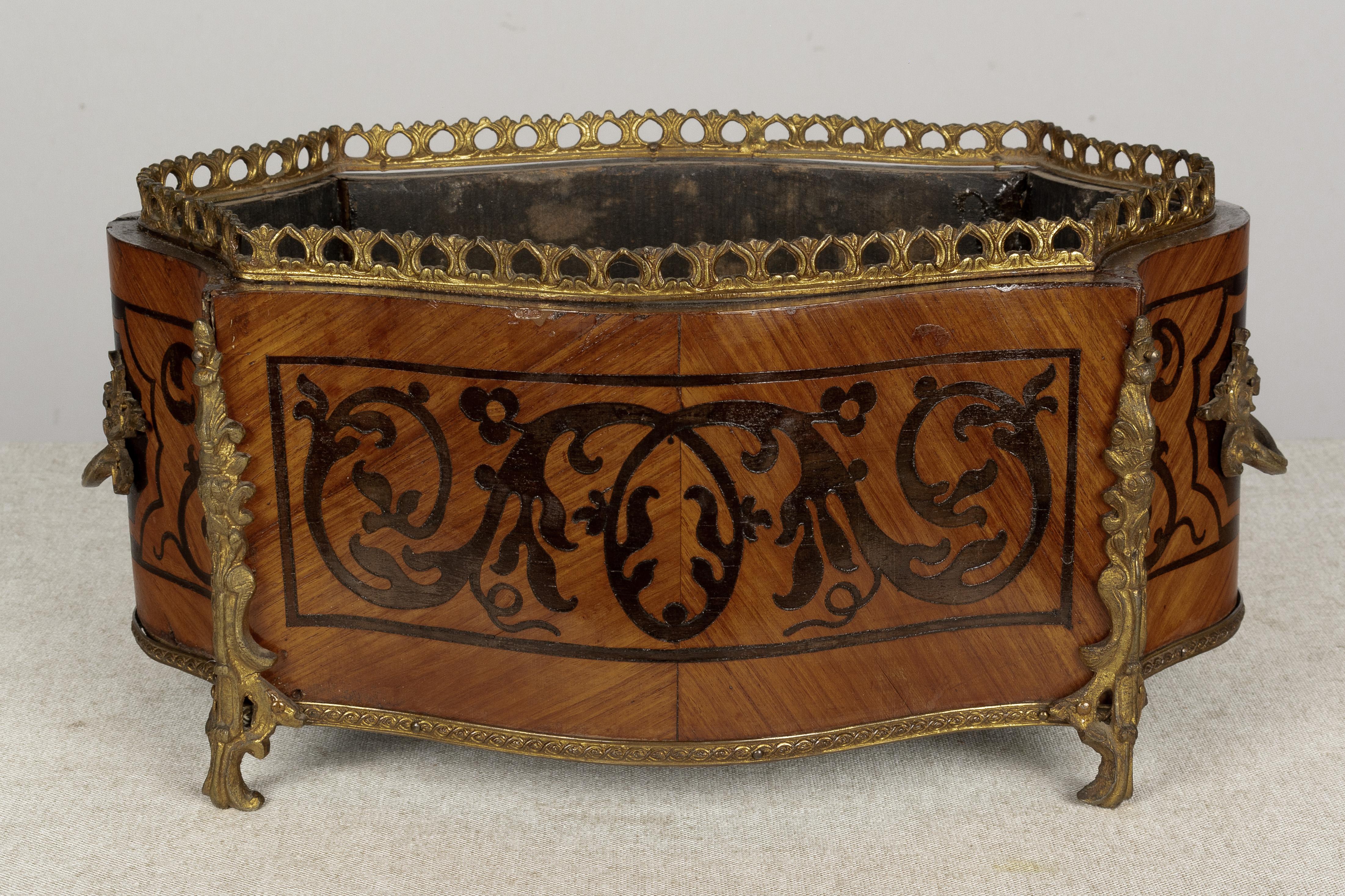 A 19th century Napoleon III style marquetry jardinière, or planter, made of veneer of mahogany with inlaid design. Bronze-mounted with two handles, gallery and corner ornaments. Missing the zinc liner. A beautiful planter for the display of orchids.