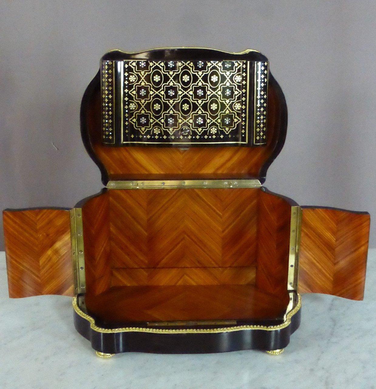 Napoleon III style liquor cabinet in blackened wood and mother-of-pearl inlays and rosewood interior.
Pad-varnished oval box.
It is garnished with its liquor servant consisting of four decanters and sixteen decorated glasses (including 5 slightly