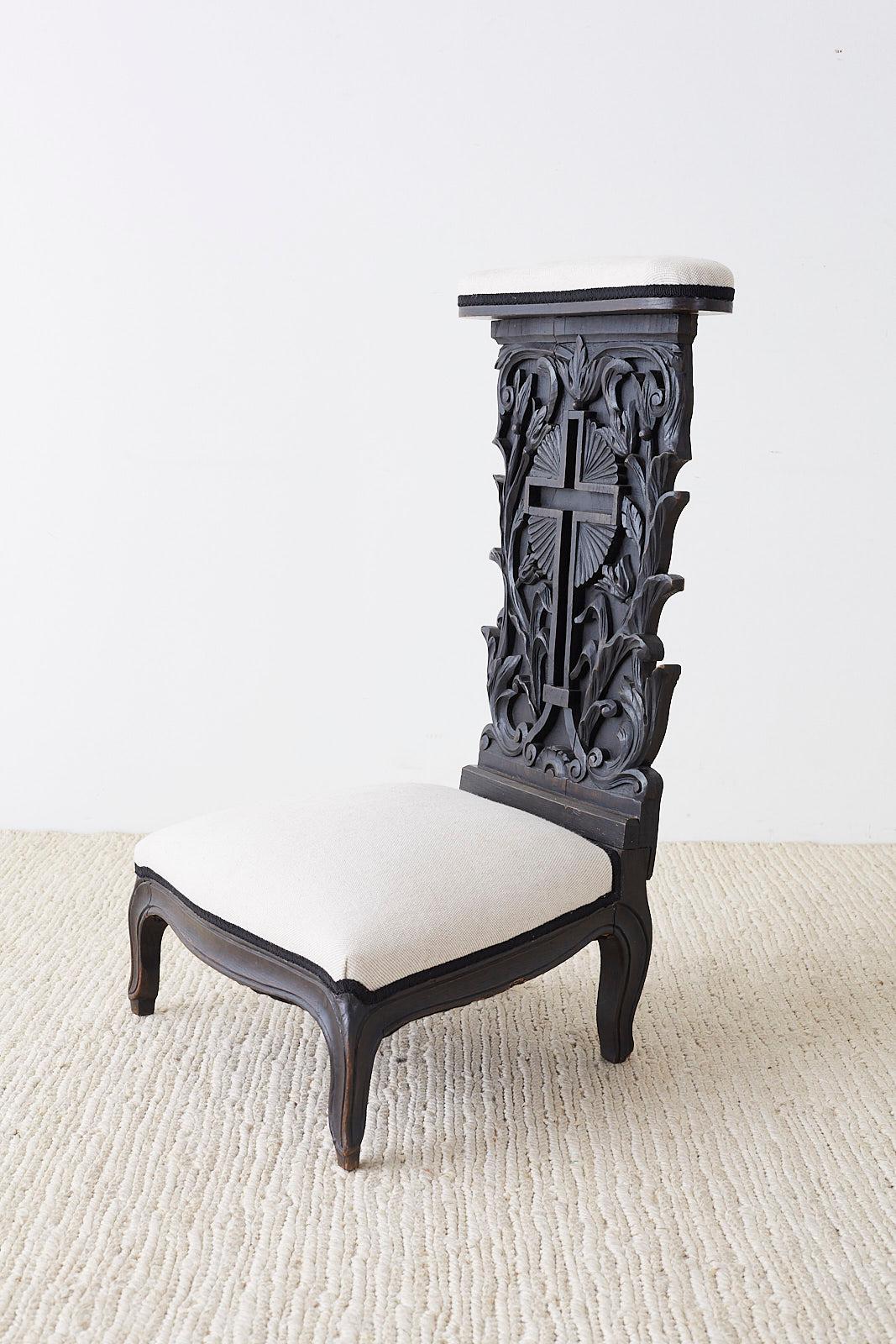 Dramatic 19th century French Napoleon III period Prie-Dieu prayer chair. hand carved from oak featuring an ebonized finish and new linen upholstery. The chair back is centered by a hollow cross flanked by floral and foliate vines on each side with a