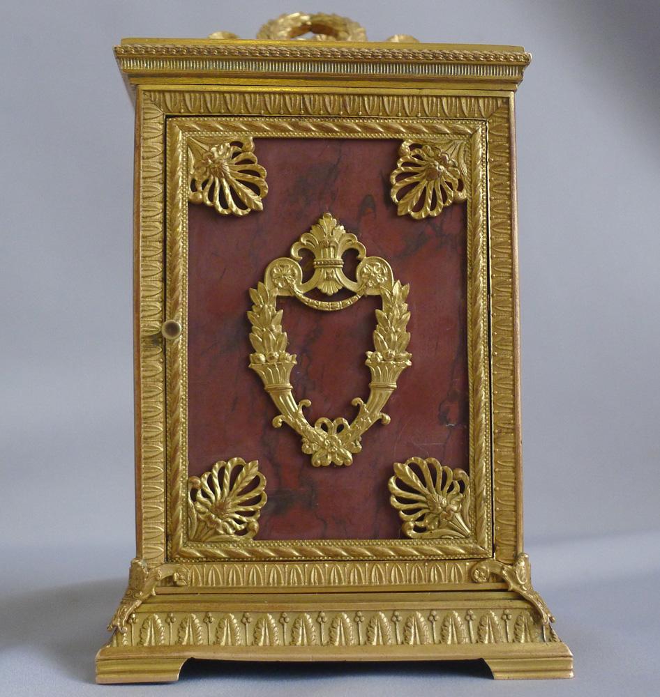Eine schöne französische Napoleon-III-Wagenuhr aus Ormolu, bei der alle fünf Tafeln in rotem Marmor montiert sind. Die Marmortafeln sind mit originalen neoklassizistischen Figuren und Akanthus aus vergoldeter Bronze verkleidet. Das runde Zifferblatt