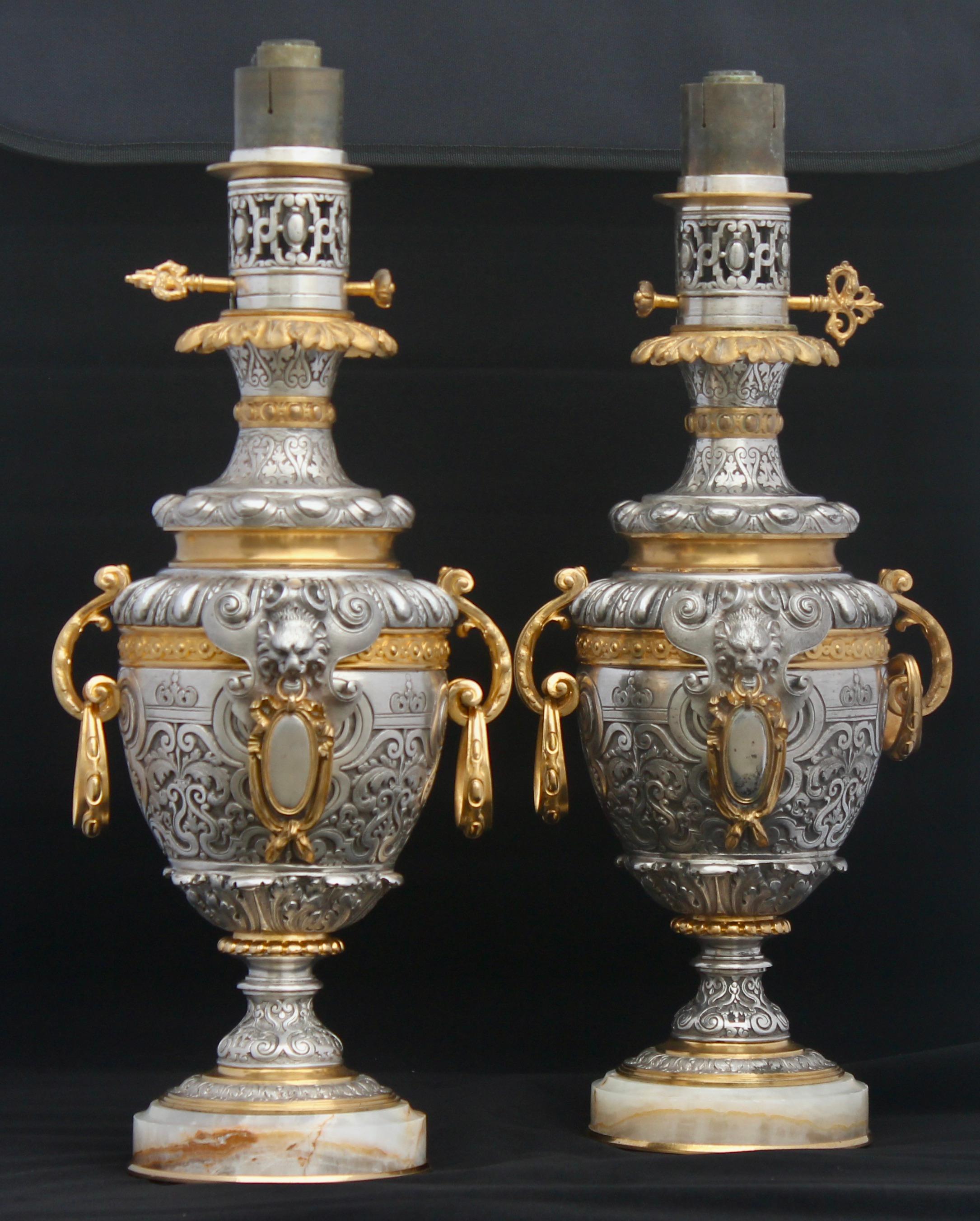 A French Napoléon III ormolu-mounted and silvered bronze pair of lamps 
Very finely chiseled design with Lion's head holding medallions, acanthus leaves, godrons, arabesques and rosaces, with two detached handles,
Resting on onyx bases
Original