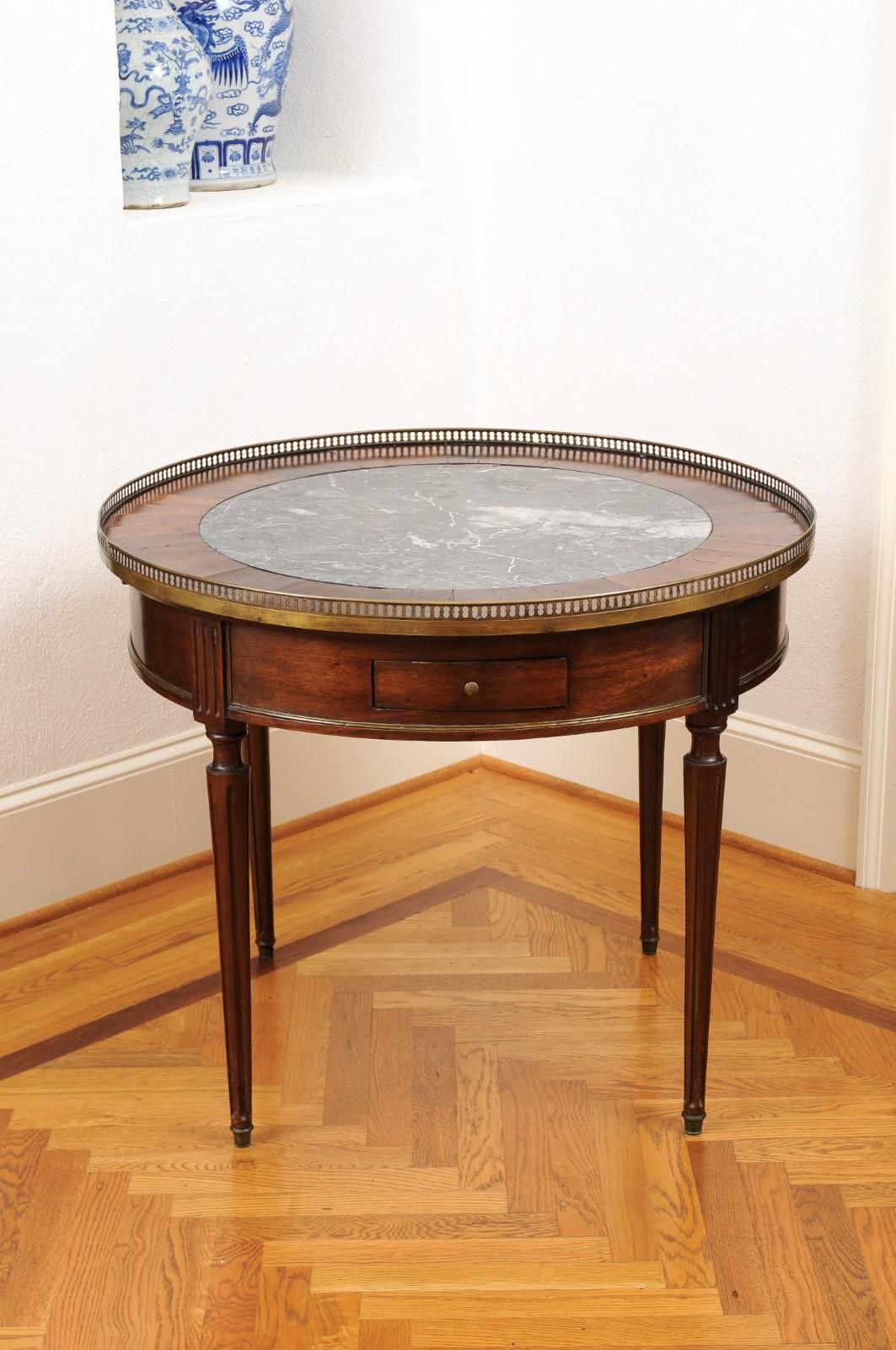 A French Napoléon III period bouillotte table from the mid-19th century, with marble top and pierced gallery. Created in France at the beginning of the reign of Emperor Napoléon III, this bouillotte table features a circular top with grey marble