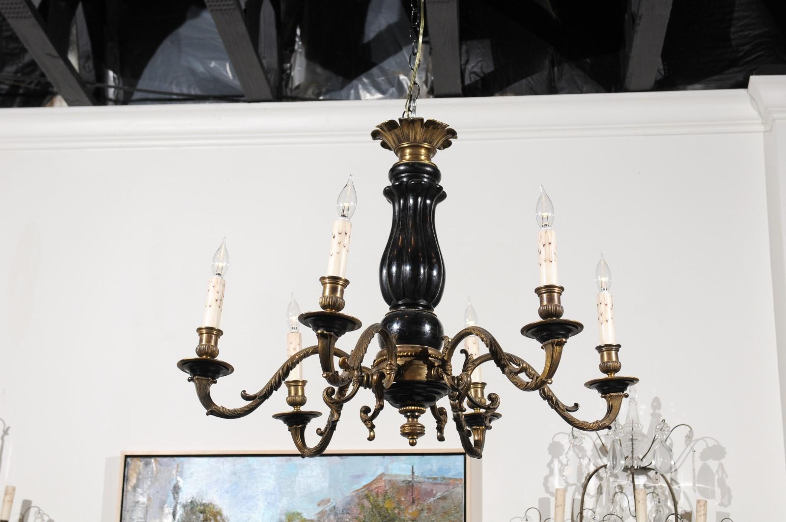 A French Napoleon III period carved ebonized wood and bronze six-light chandelier from the mid-19th century, with scrolling arms and acanthus leaf motifs. Born in France during the reign of France's last emperor Napoleon III, this exquisite