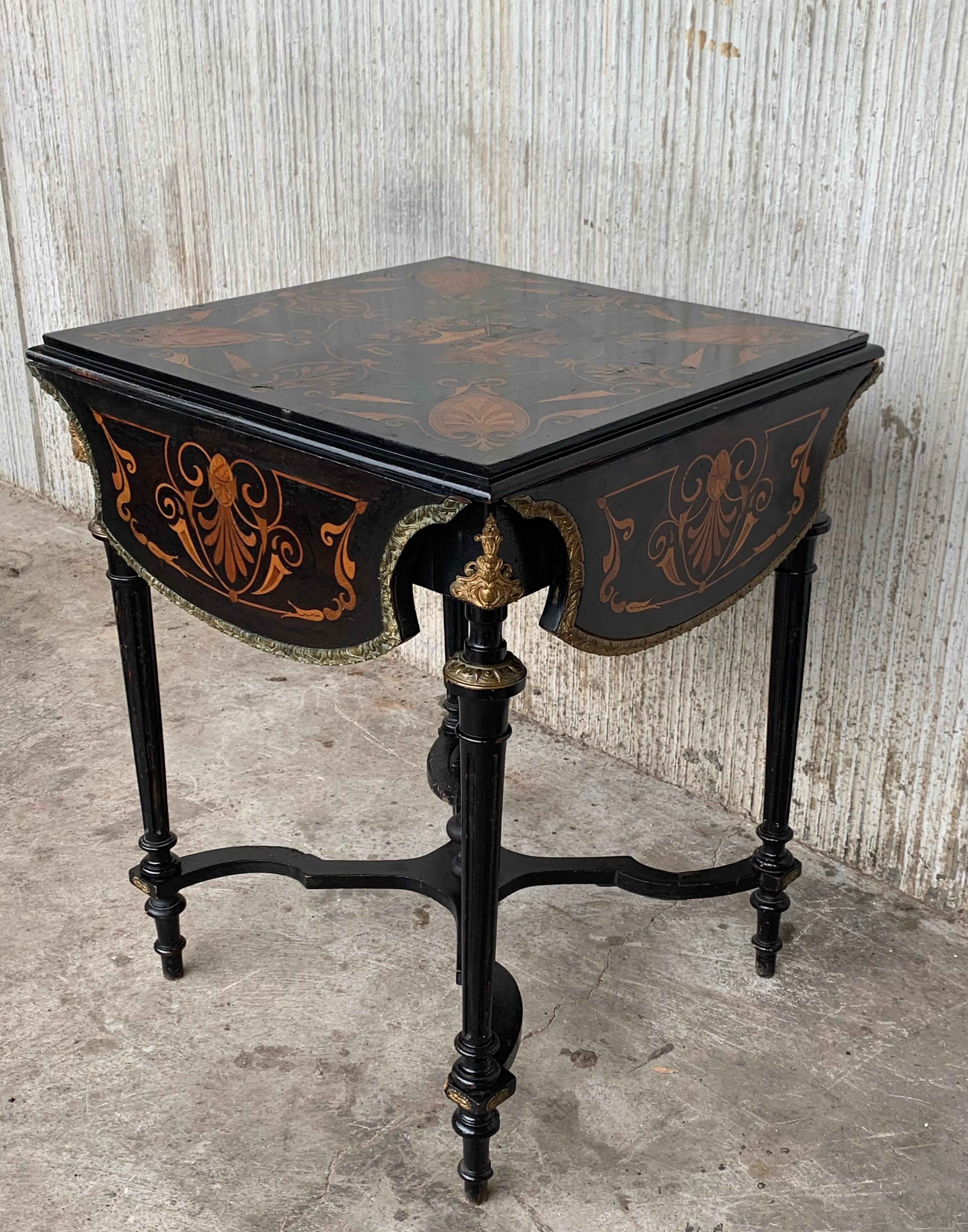 French Napoleon III period vanity table, ebonized frame accented with burlwood panels, hinged top with marquetry ornaments, oak branches, and floral blooms, rising on tapered legs, joined by a cross stretcher, ending in turned feet.

Open