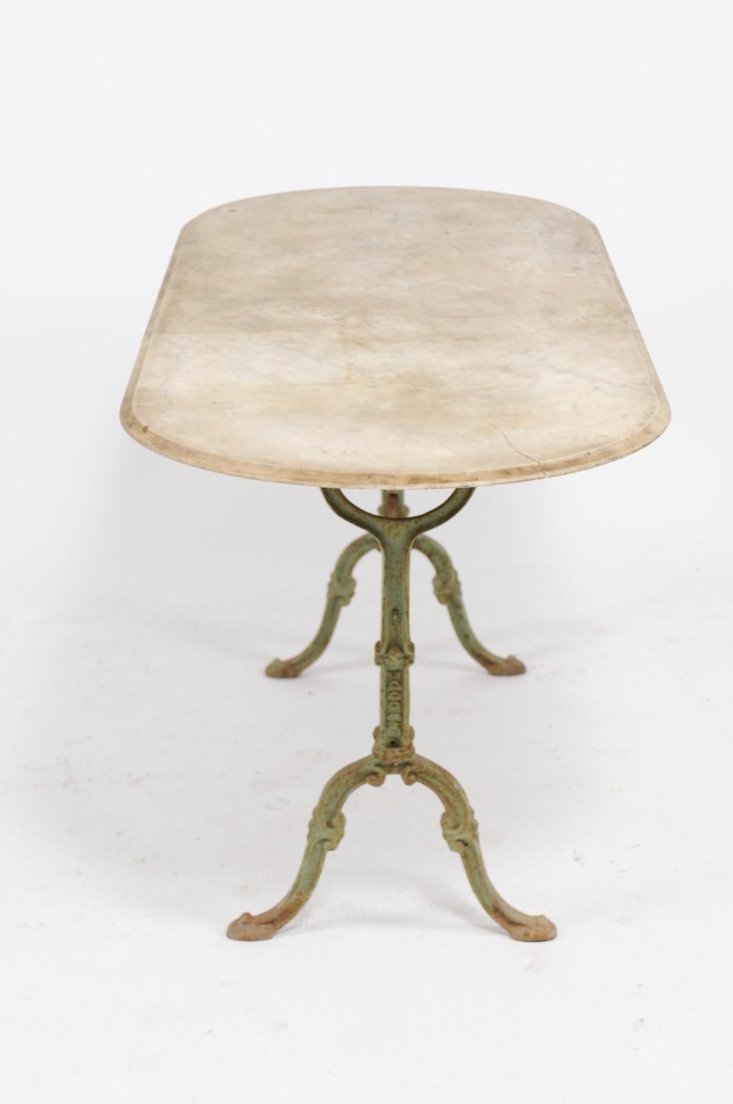 A French Napoleon III period iron bistro table from the mid-19th century, with oval marble top. Born in France during the early years of Emperor Napoleon III's reign, this authentic French bistro table features an oval marble top sitting above an