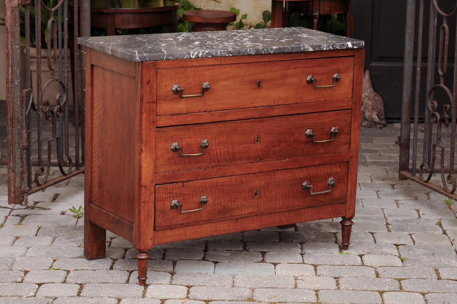 A French Napoleon III period walnut three-drawer commode from the mid 19th century, with grey variegated marble top and turned feet. Born in France during the early years of Emperor Napoleon III's reign, this elegant commode features a grey