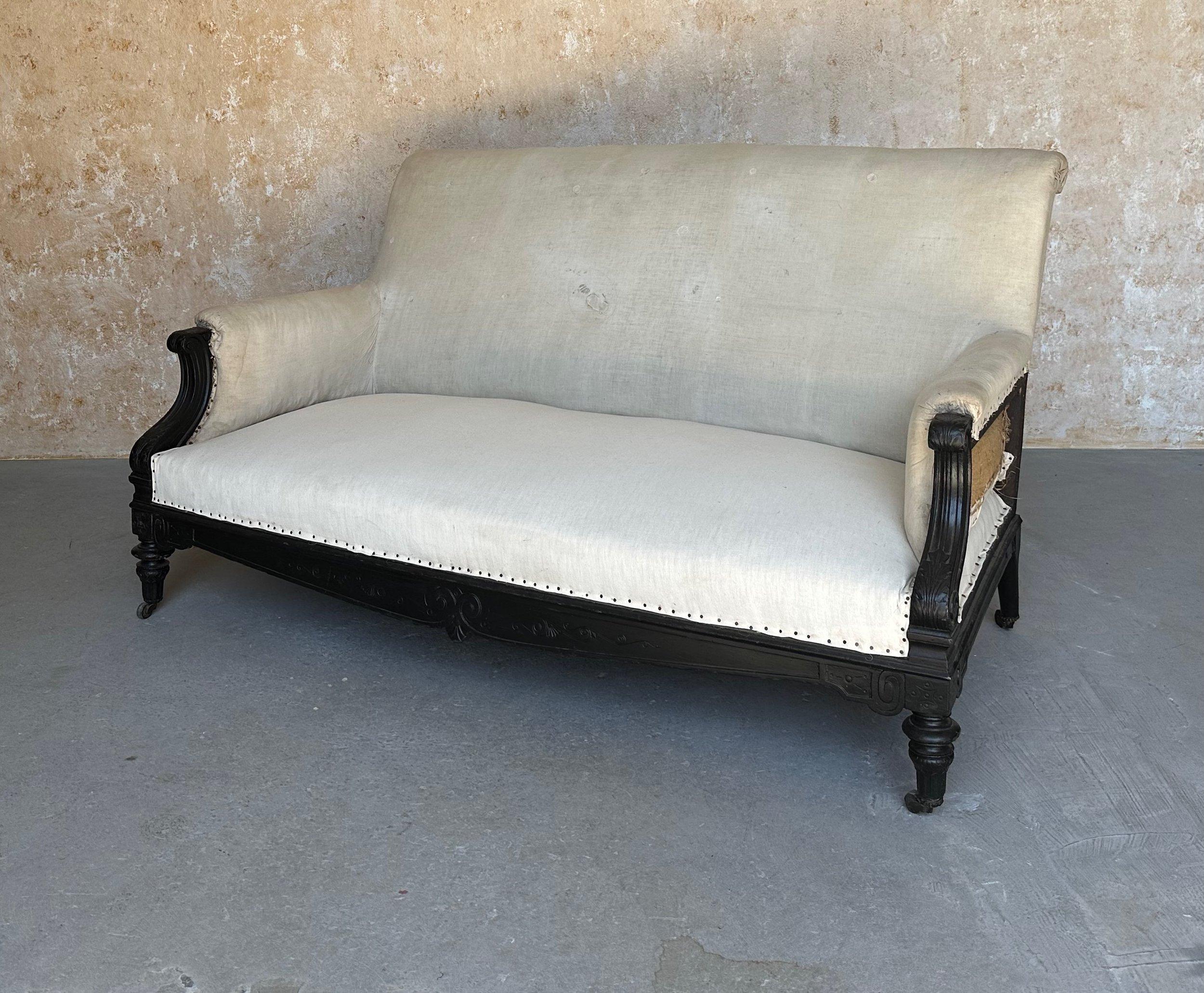 Canapé Napoléon III français du 19ème siècle avec décorations et peintures.  cadre. La pièce de résistance de ce canapé exquis réside dans ses accoudoirs ébonisés, qui dégagent un air de grandeur et de sophistication, le distinguant de tout autre
