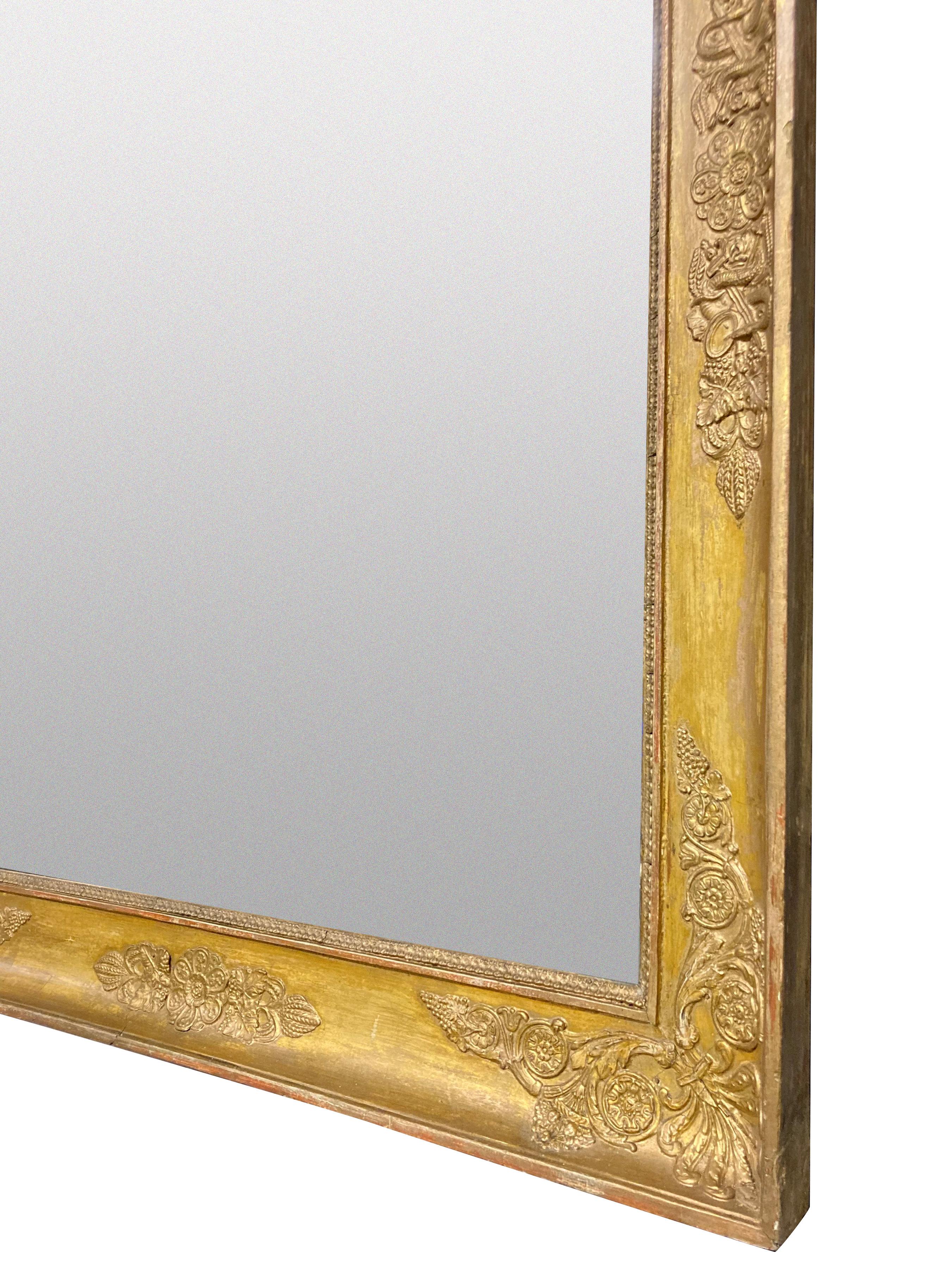 Un beau miroir français Napoléon III en bois sculpté et doré avec une décoration d'acanthe et de trophée. La plaque de mercure fendue d'origine.