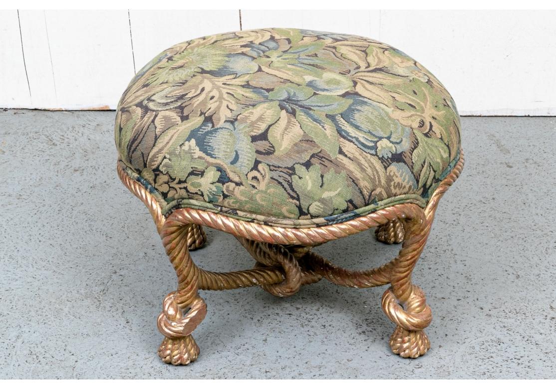 A fantastic and very decorative French Pouf Ottoman with an intricate Gilt Wood Knotted Rope base. With good size and a high Cushion custom upholstered in a William Morris type Leaf Pattern fabric in Browns, Tans and Sage Green. 

Measurements: The