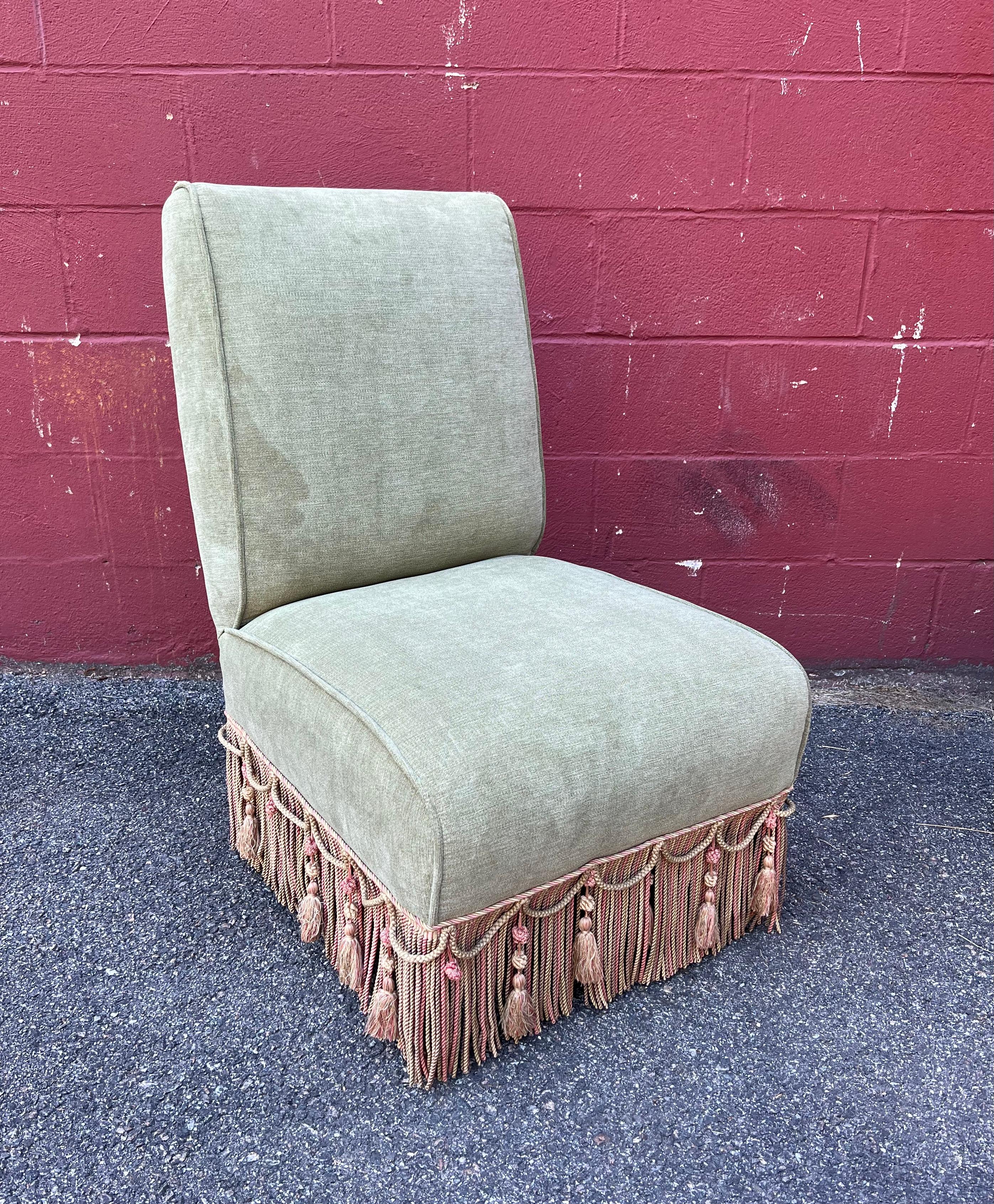 An elegant large scale French 1920s Napoleon III style slipper chair in pale green velvet. This French slipper chair is a magnificent piece of furniture. Upholstered in a pale green velvet, it boasts an elaborately trimmed design featuring