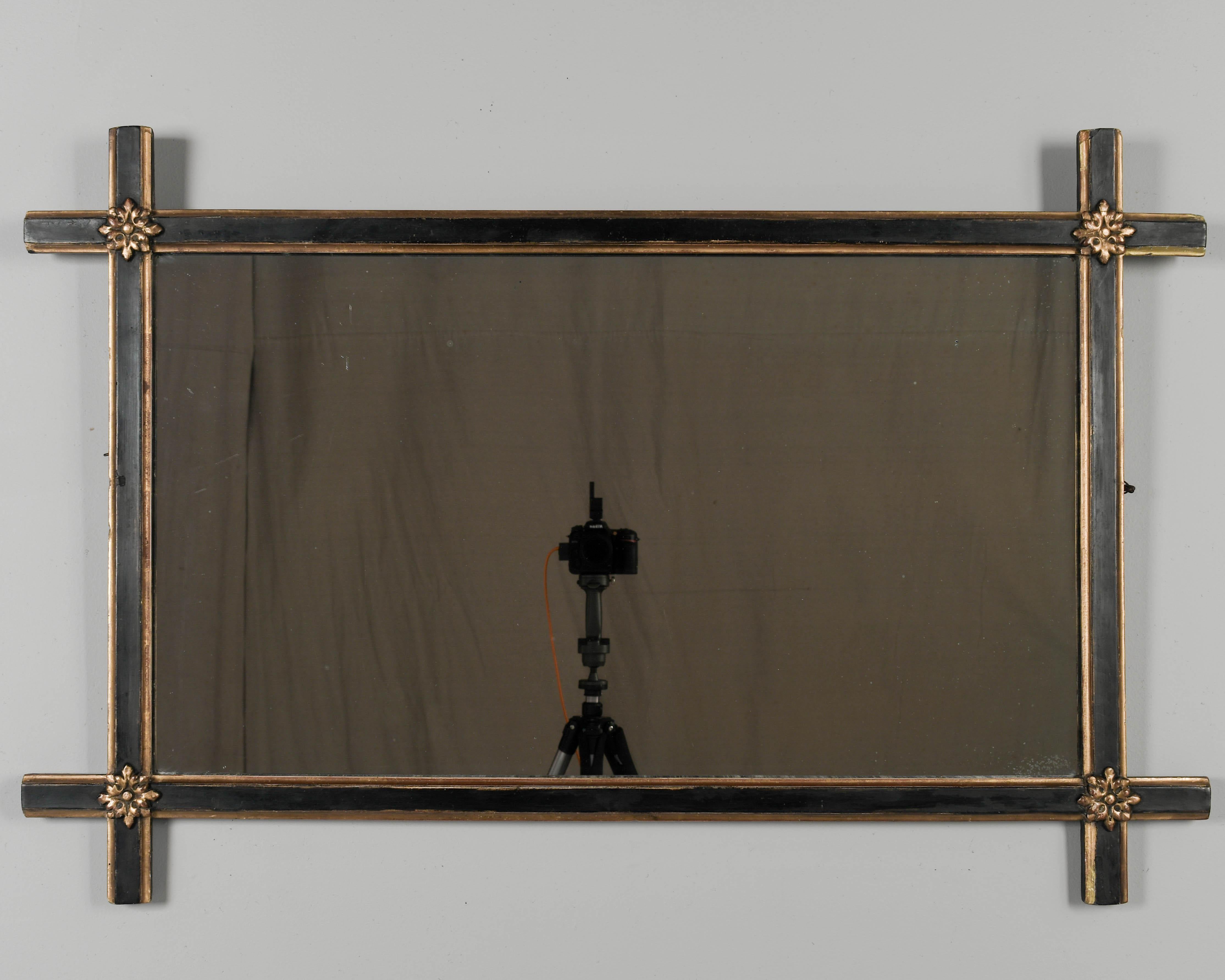 An early 20th Century French Napoleon III style mirror with black painted patina, gilded trim and applied rosettes. All original. Circa 1900-1920
Dimensions: 44.5