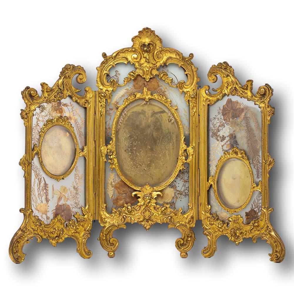 Fine French late 19th century ormolu mounted photo frame. The frame beautifully cast with a gilded bronze scrolling patterned surround. The boarder sweeping across the top of the frame in three separate sections hinged from top to bottom between