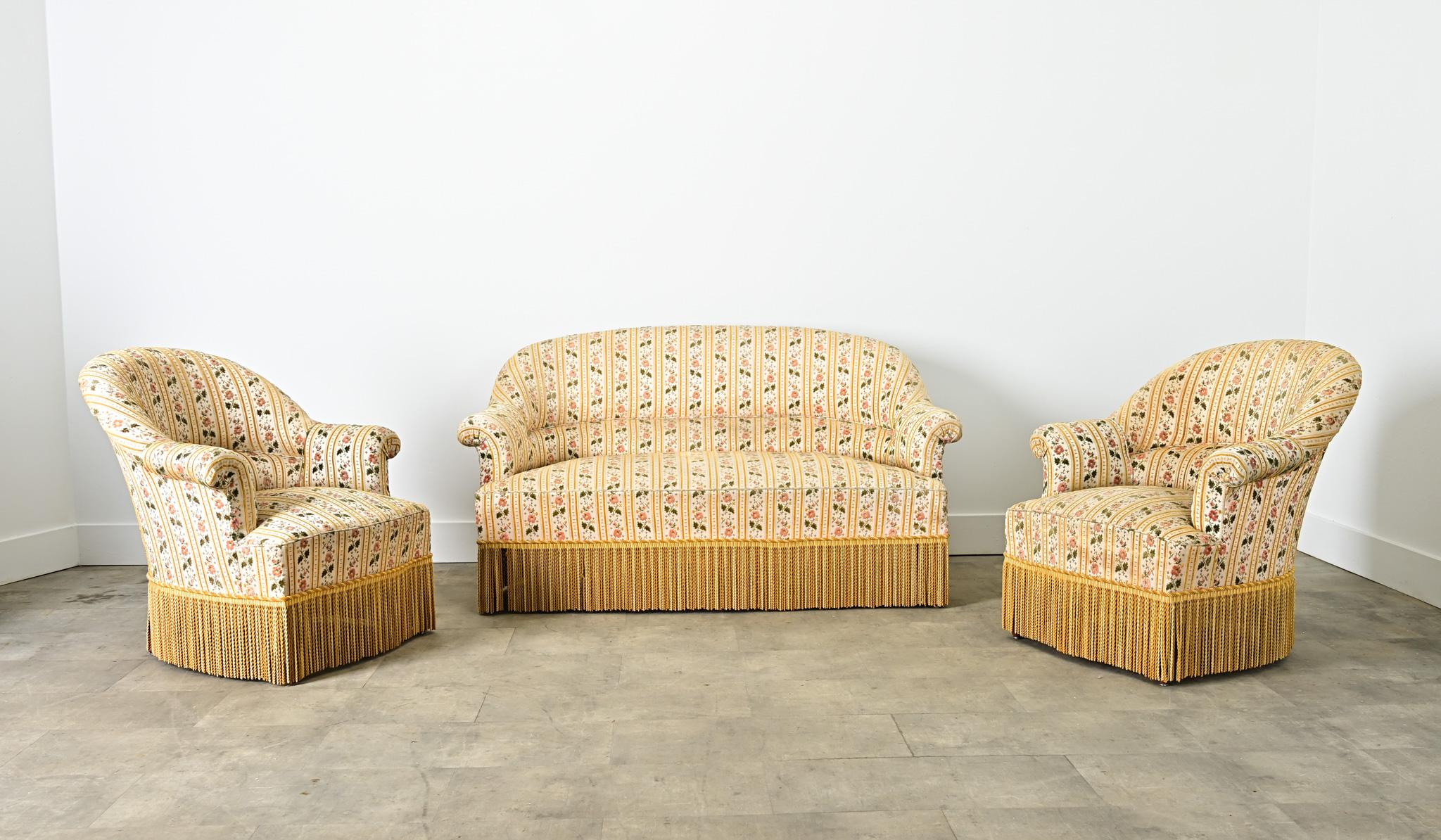 Fabuloso juego de salón francés de tres piezas del siglo XIX al estilo de Napoleón III, compuesto por un sofá y dos sillones con respaldos clásicos y curvilíneos que terminan en pequeños brazos enrollados. La tapicería actual es de diseño rayado de