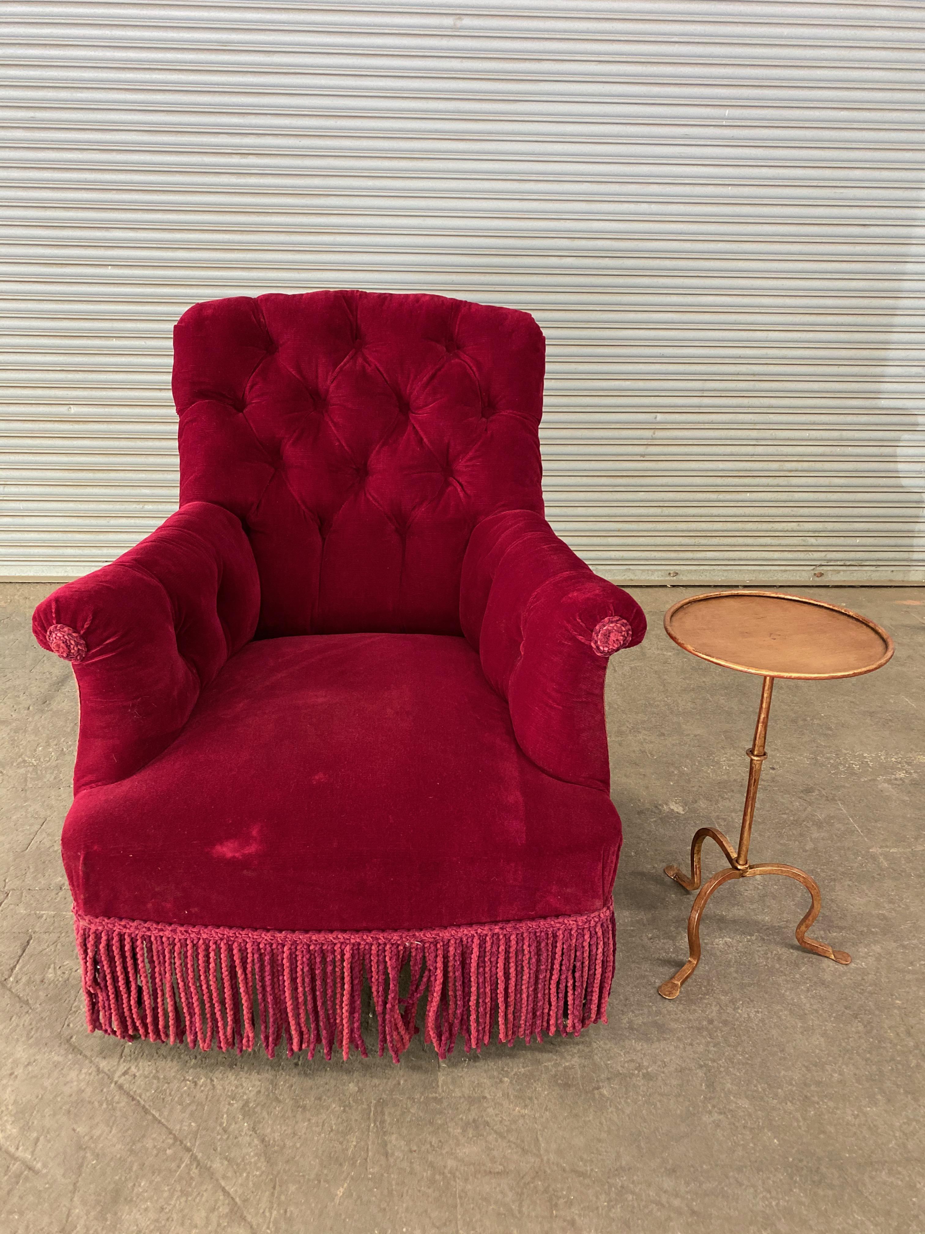 A handsome French 19th tufted armchair upholstered in red velvet with matching bullion fringe. The armchair is in very good vintage condition, and while the upholstery is not new, the fabric is clean and can be used. Sold as is.
 