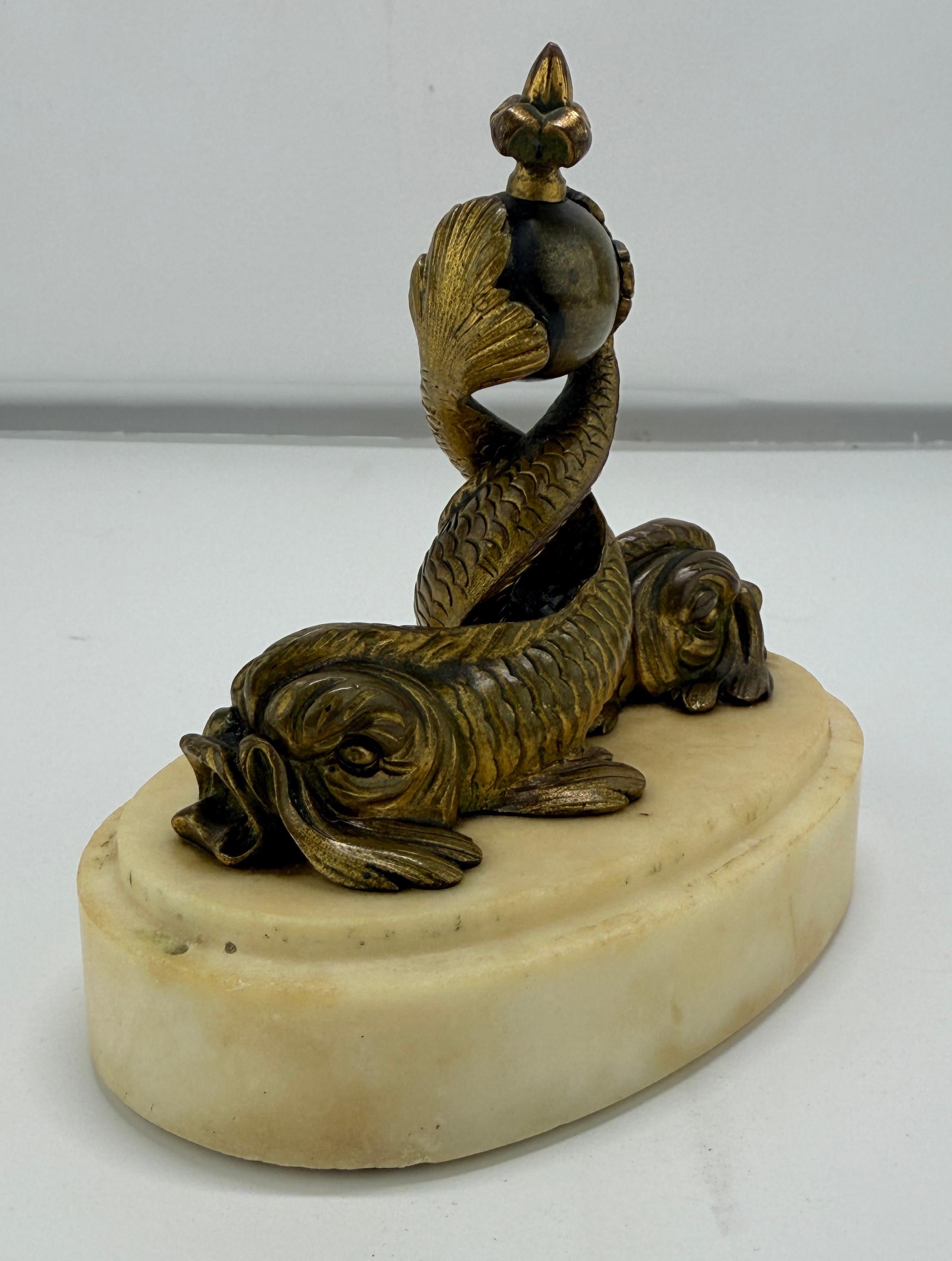 Objet sculptural en bronze et en marbre à vocation symbolique et décorative, cette pièce française de la fin du XIXe siècle est fondue dans le style néo-napoléonien et prend la forme d'un fleuron ou d'une monture héraldique, qui couronnait peut-être