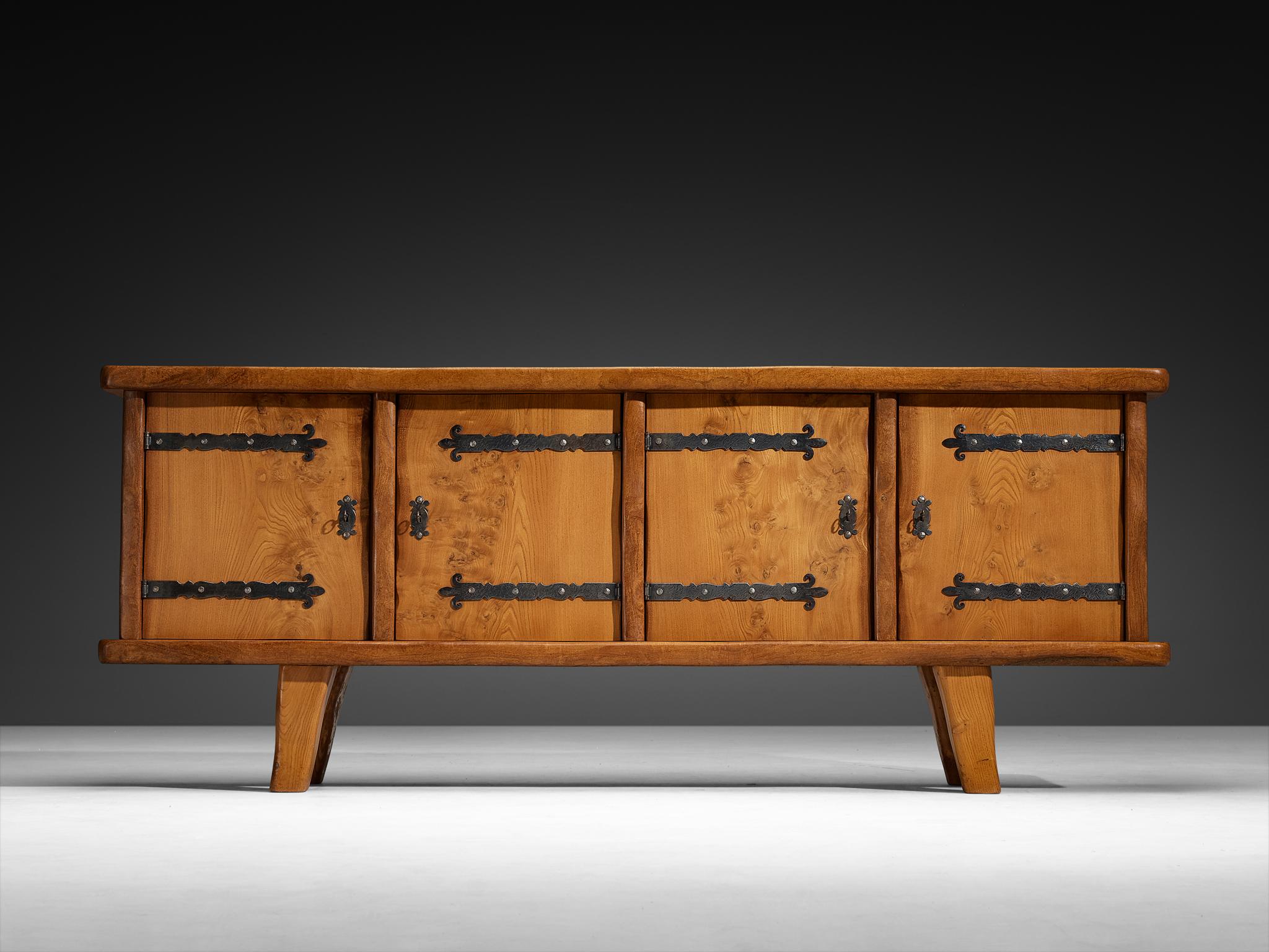 Sideboard, elm, iron, France, 1970s/1980s

This French sideboard expresses a naturalistic and grounded character. Crafted from solid elm, its robust form reveals the wood’s inherent beauty through visible knots, warm tones, and natural variations in