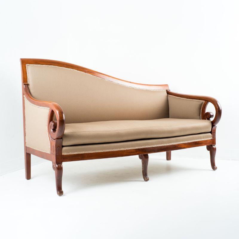 Neoclassic Cubus mahogany framed meridienne sofa with ram's horn arms. The sofa is constructed of solid mahogany with no secondary woods or veneers. The seat and back frame is upholstered in wool satin with braided gimp over horse hair fill with