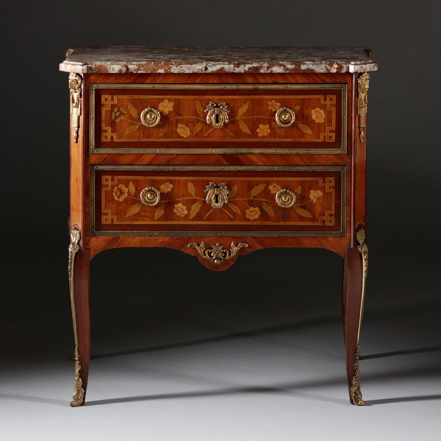A fine late 18th-century master cabinet maker marquetry commode, supporting a rouge Languedoc marble top with shaped profile, the commode with two short drawers with floral marquetry, original gilt bronze border and lion mask mounts and round drop