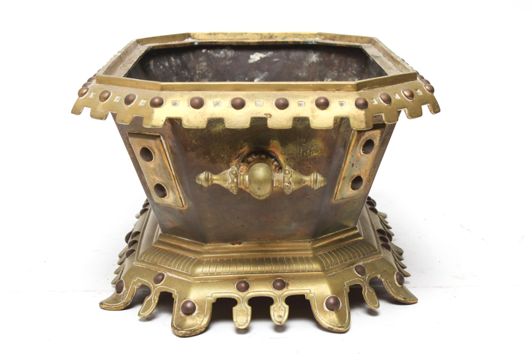 French neo-Gothic style jardinière in gilt bronze in an elongated hexagonal shape with applied metal panels and handles. The interior is lead-lined. Some age-appropriate wear and patina to the metal surfaces, but overall in great vintage condition.