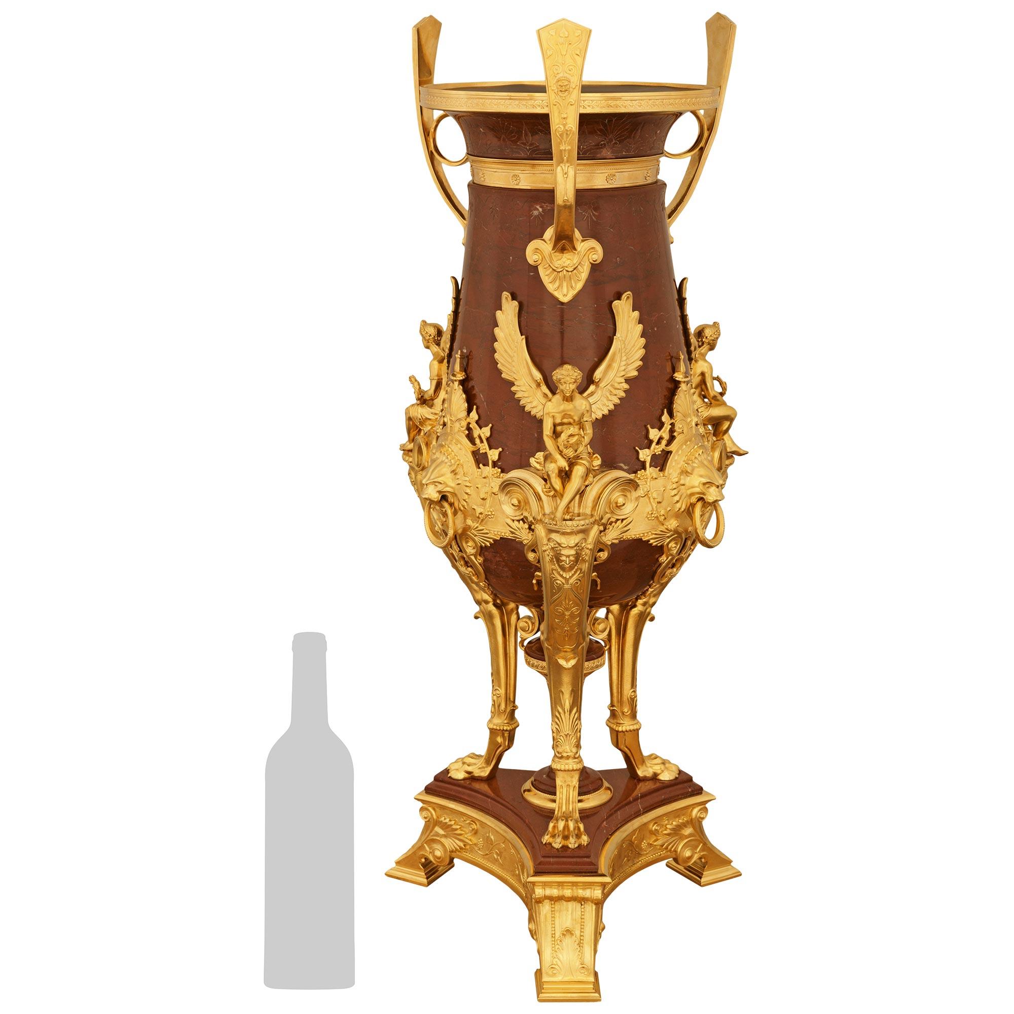 Impressionnant et monumental vase néo-grec français du XIXe siècle en bronze doré et marbre rouge griotte, attribué à Barbedienne. Ormolu et Marbre Rouge Griotte, attribué à Barbedienne. Ce superbe vase repose sur une base triangulaire aux côtés