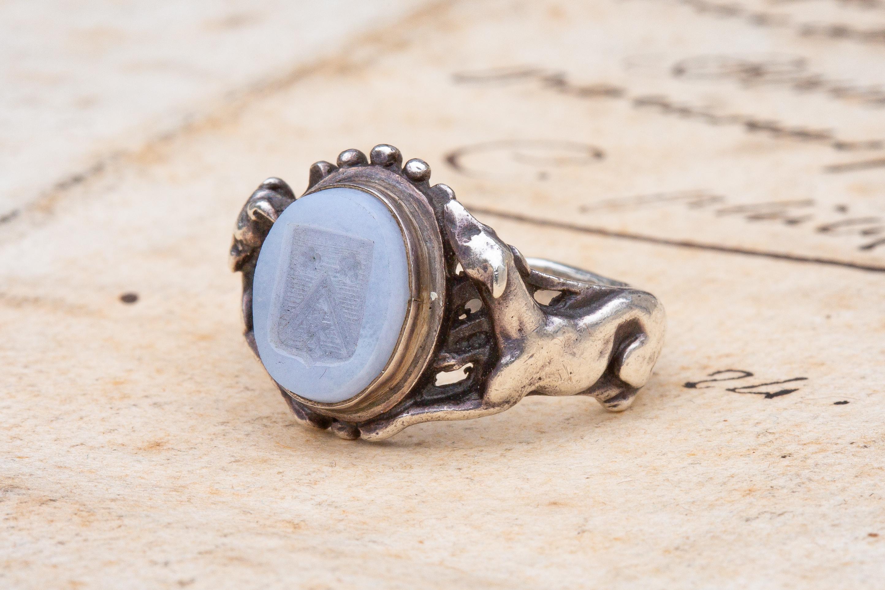 A fantastic French 19th century Neorenaissance silver intaglio ring, in the manner of Jules Wièse and Froment-Meurice, circa 1840. The milky blue chalcedony intaglio is engraved to depict a French heraldic family coat of arms with two roses and a