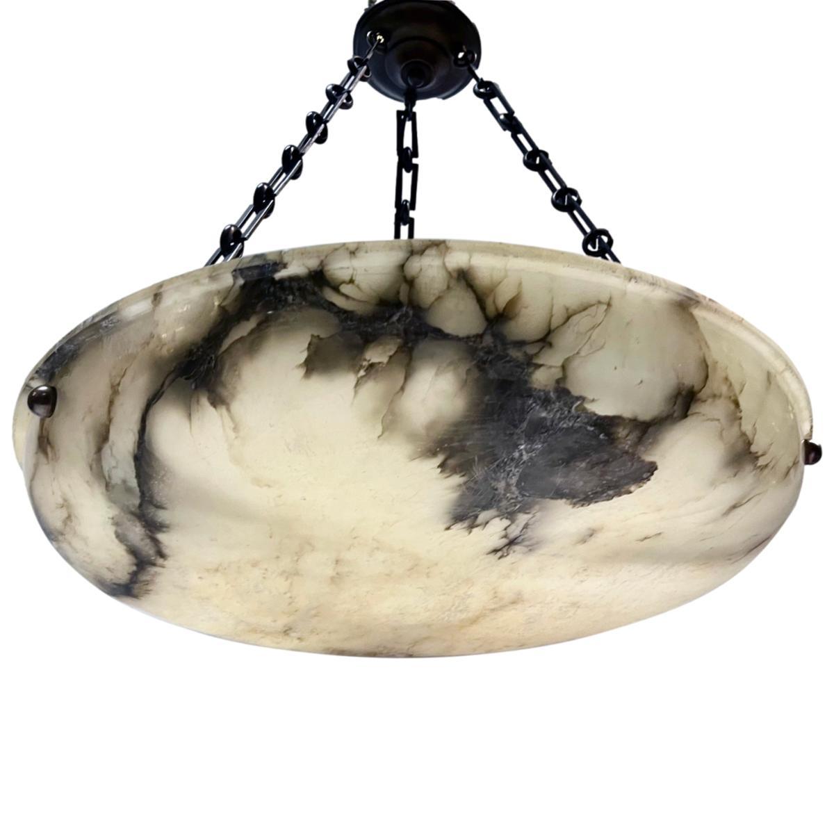 A circa 1920's French alabaster light fixture with 3 interior lights.

Measurements:
Diameter: 23