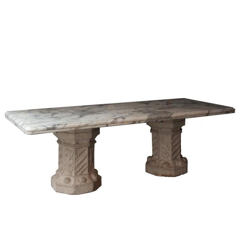 Dining table from the Medinaceli Palace in Madrid built in 1864. 
It is composed by an imposing Arabescato marble top and a base composed of two legs in the shape of polyhedric columns made in stone and decorated with plant motifs. The piece has a