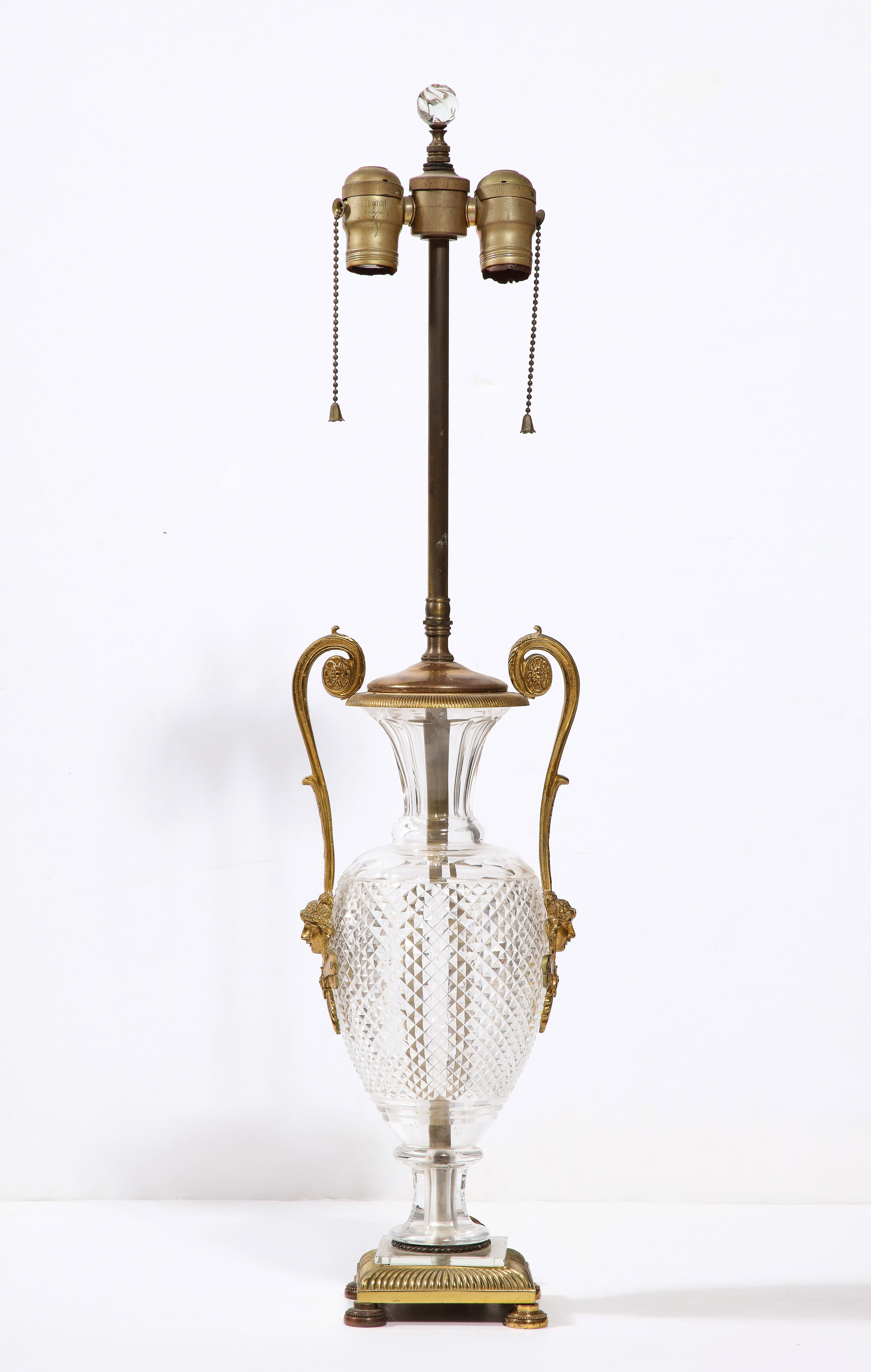 A fine French neoclassic cut crystal urn form with gilt bronze-mounted swan handles and square base.

Urn height: 15