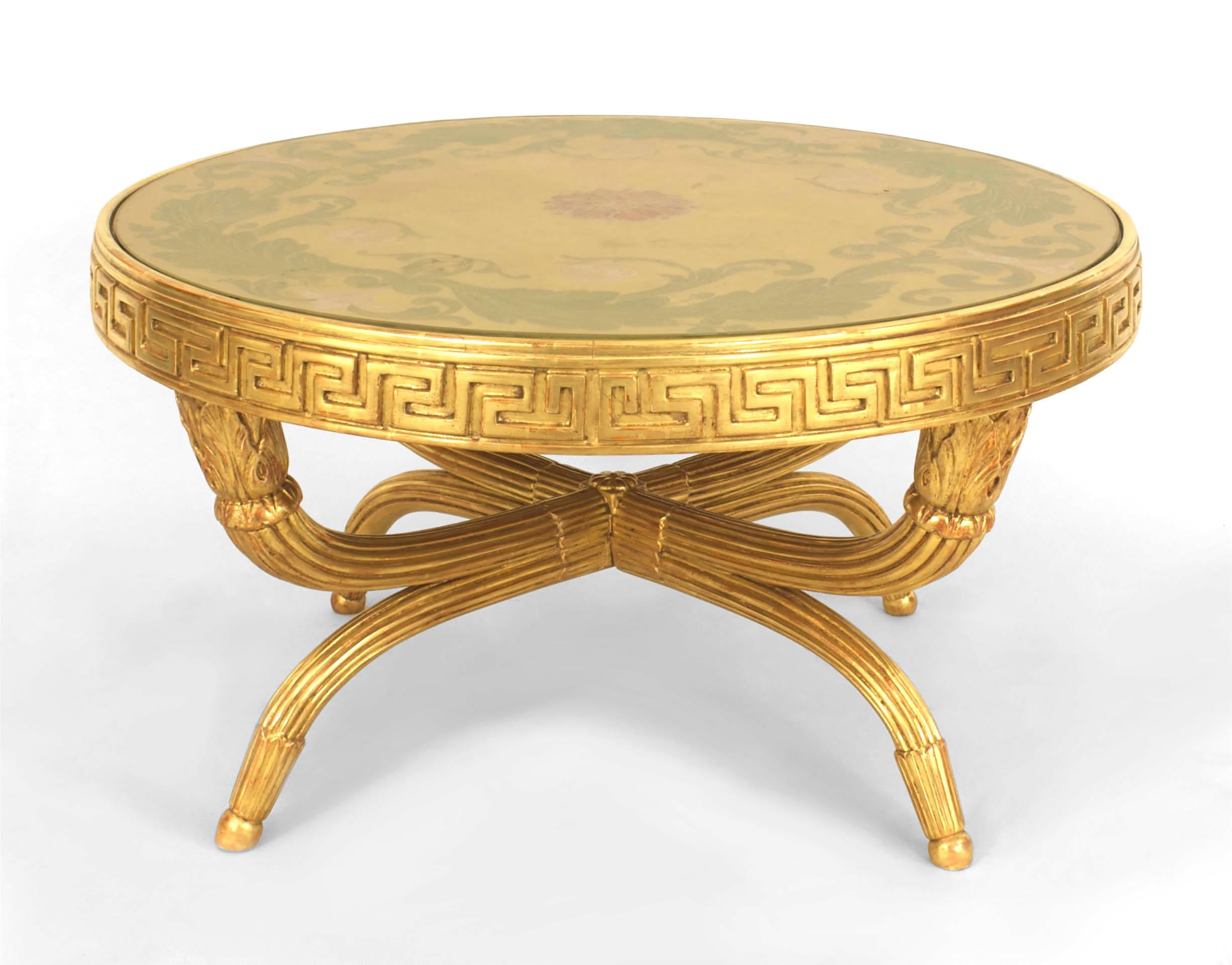 Gilt-wood round coffee table with an églomisé decorated top over a Greek key frieze supported by crossed fluted legs with acanthus tipped feet.
