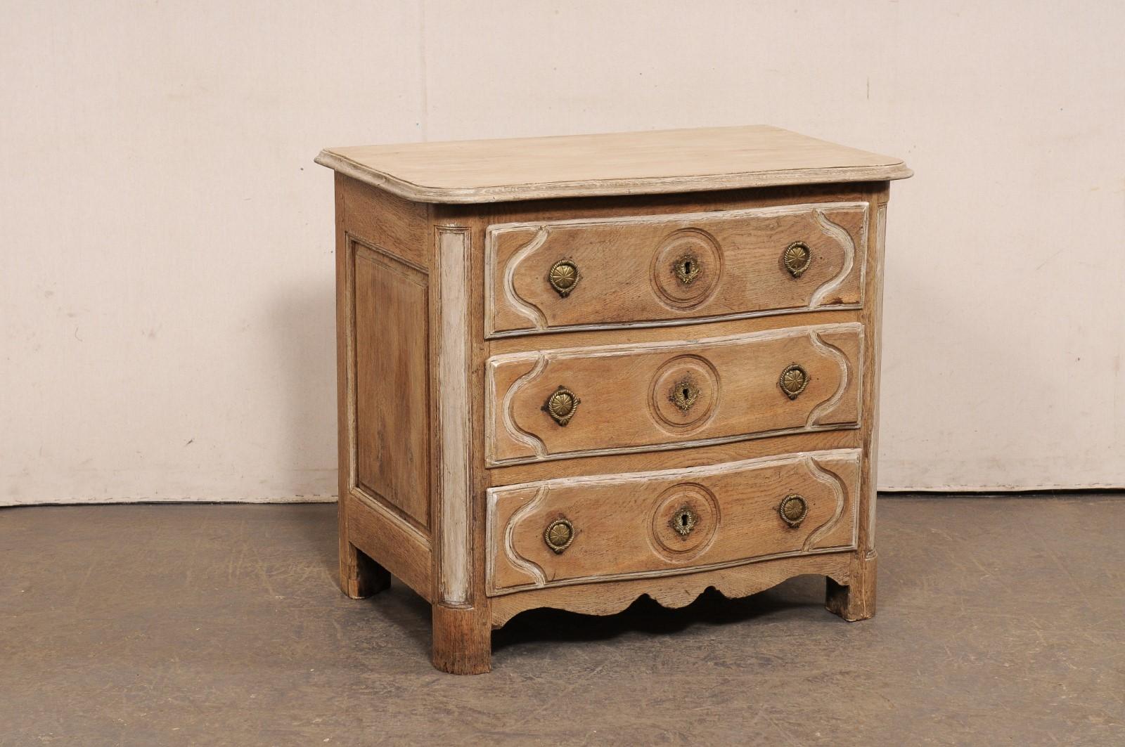 A French Neoclassic period carved-wood commode from the turn of the 18th and 19th century. This antique chest from France has a very softly curved/shallow serpentine front, which is carried from the top and down the along the three drawers at front.